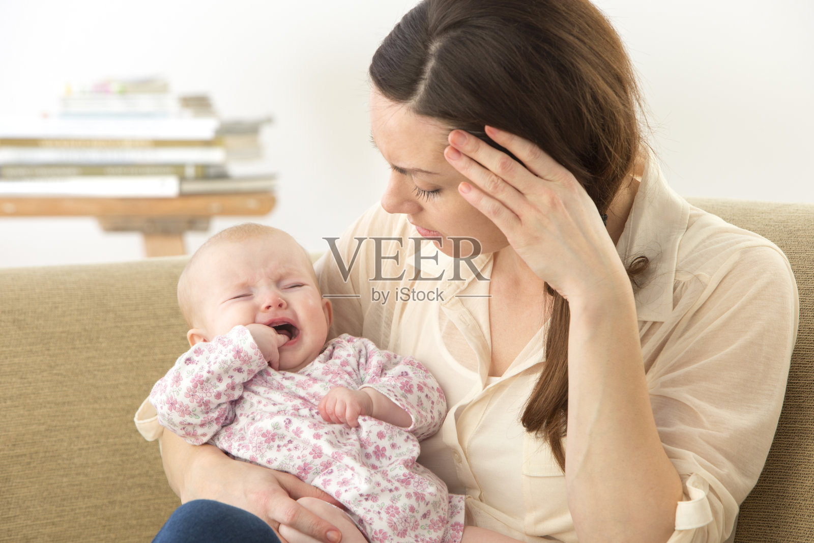 忧心忡忡的母亲与不安的婴儿出牙照片摄影图片