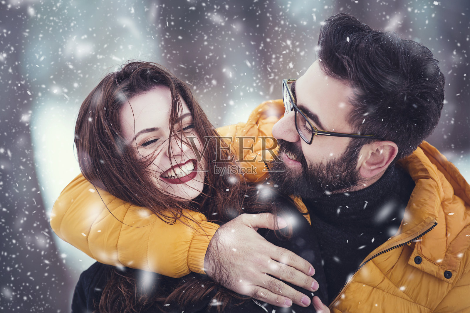 一对浪漫可爱的夫妇在一个下雪的公园里玩耍照片摄影图片