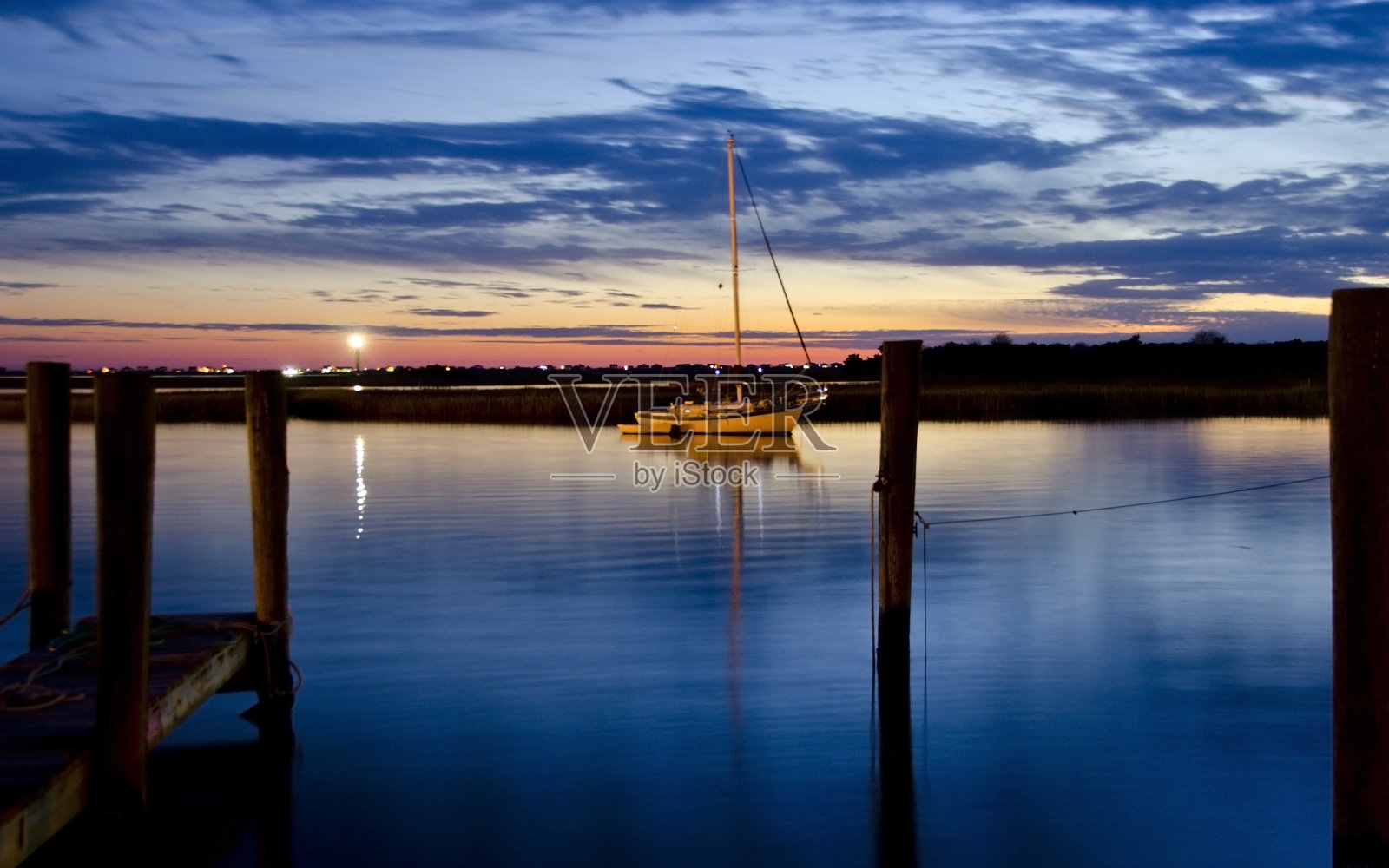 黄昏时分波光粼粼的水面上的帆船照片摄影图片