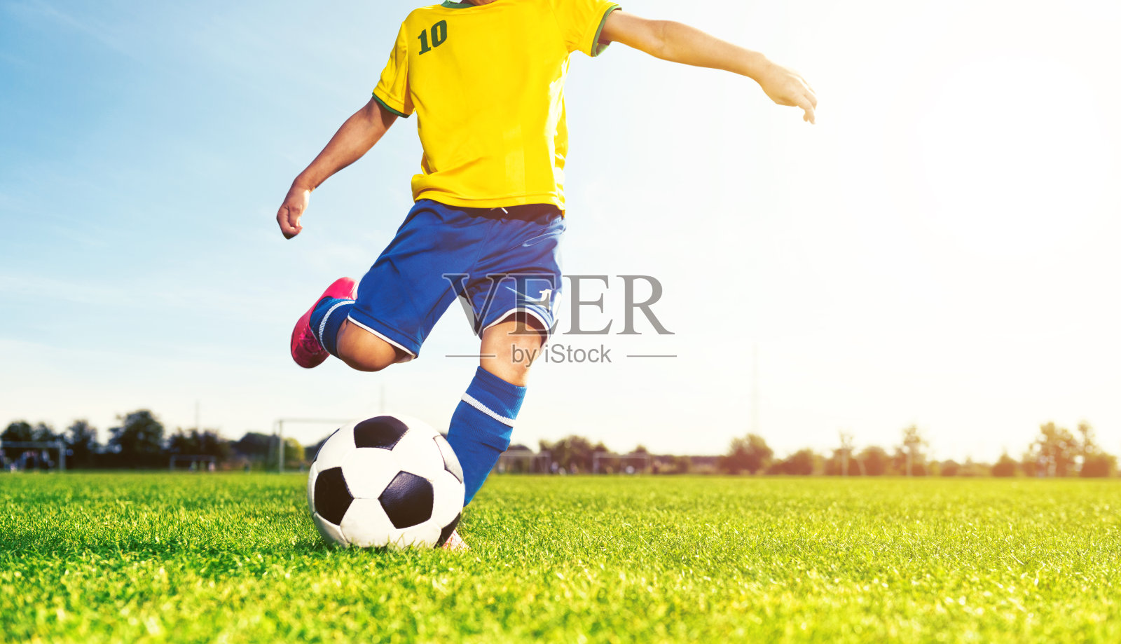 男孩在踢足球比赛照片摄影图片