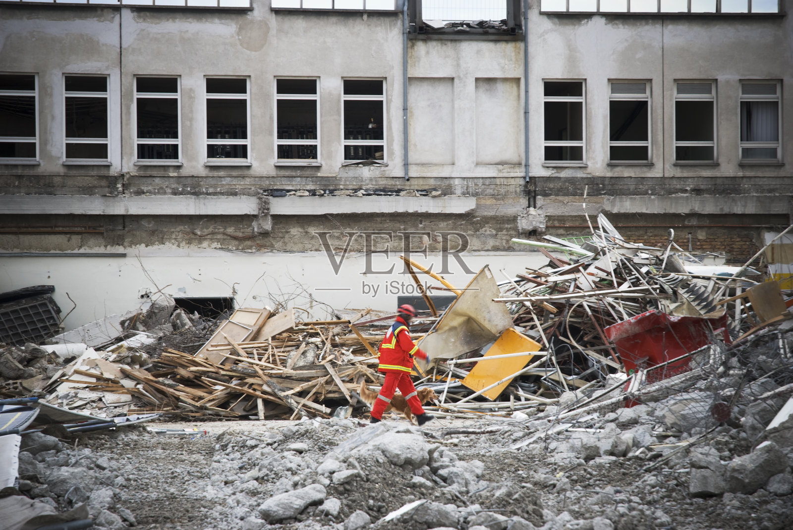 救援人员行走在被拆毁的建筑物残骸上照片摄影图片