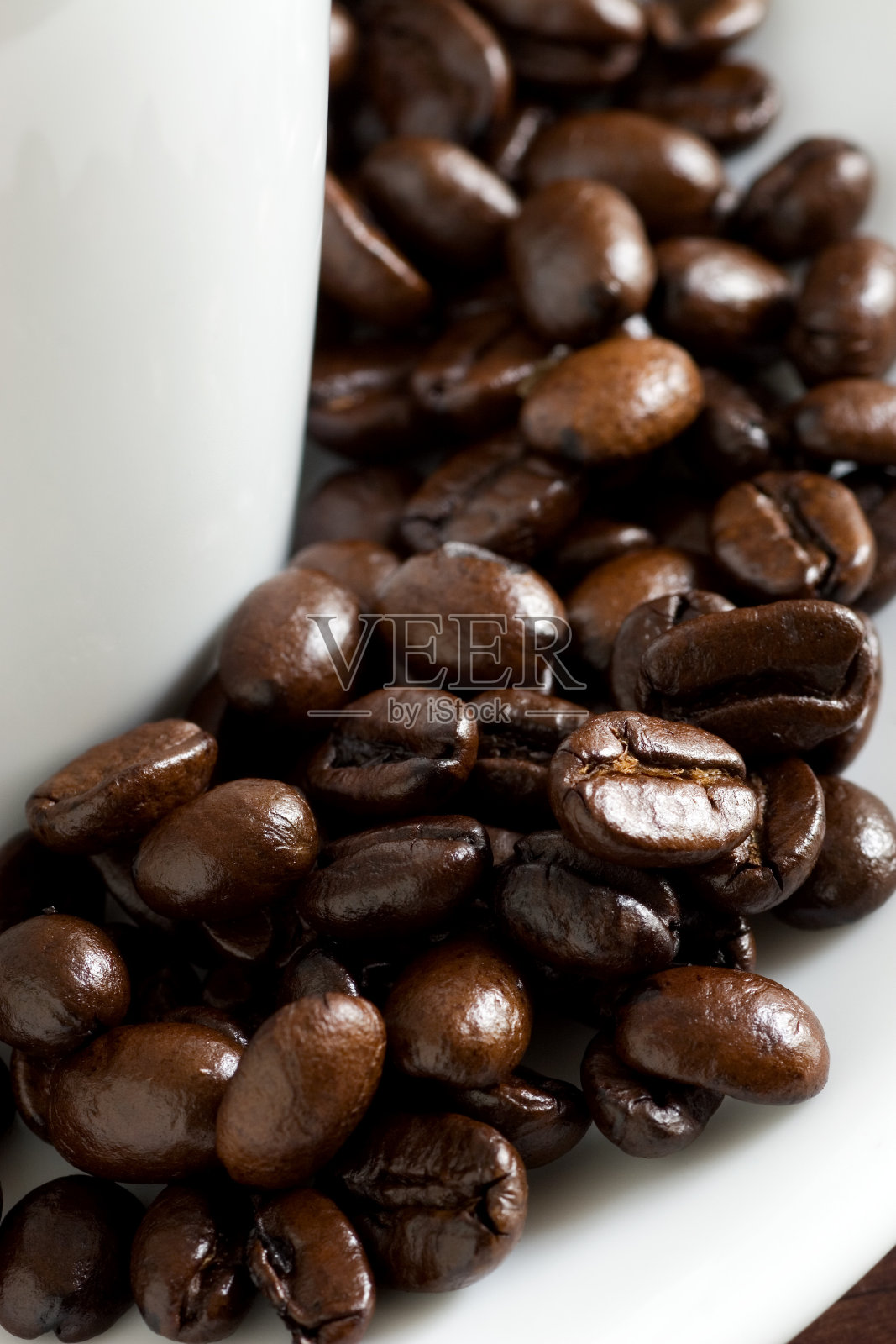 杯边的新鲜烘培咖啡豆。照片摄影图片