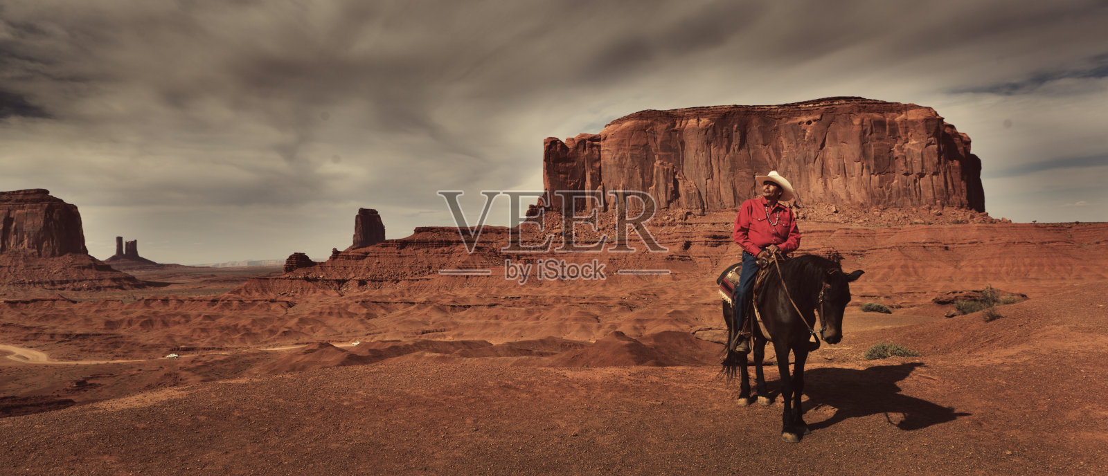 在纪念碑谷部落公园骑马的美国土著西部牛仔照片摄影图片