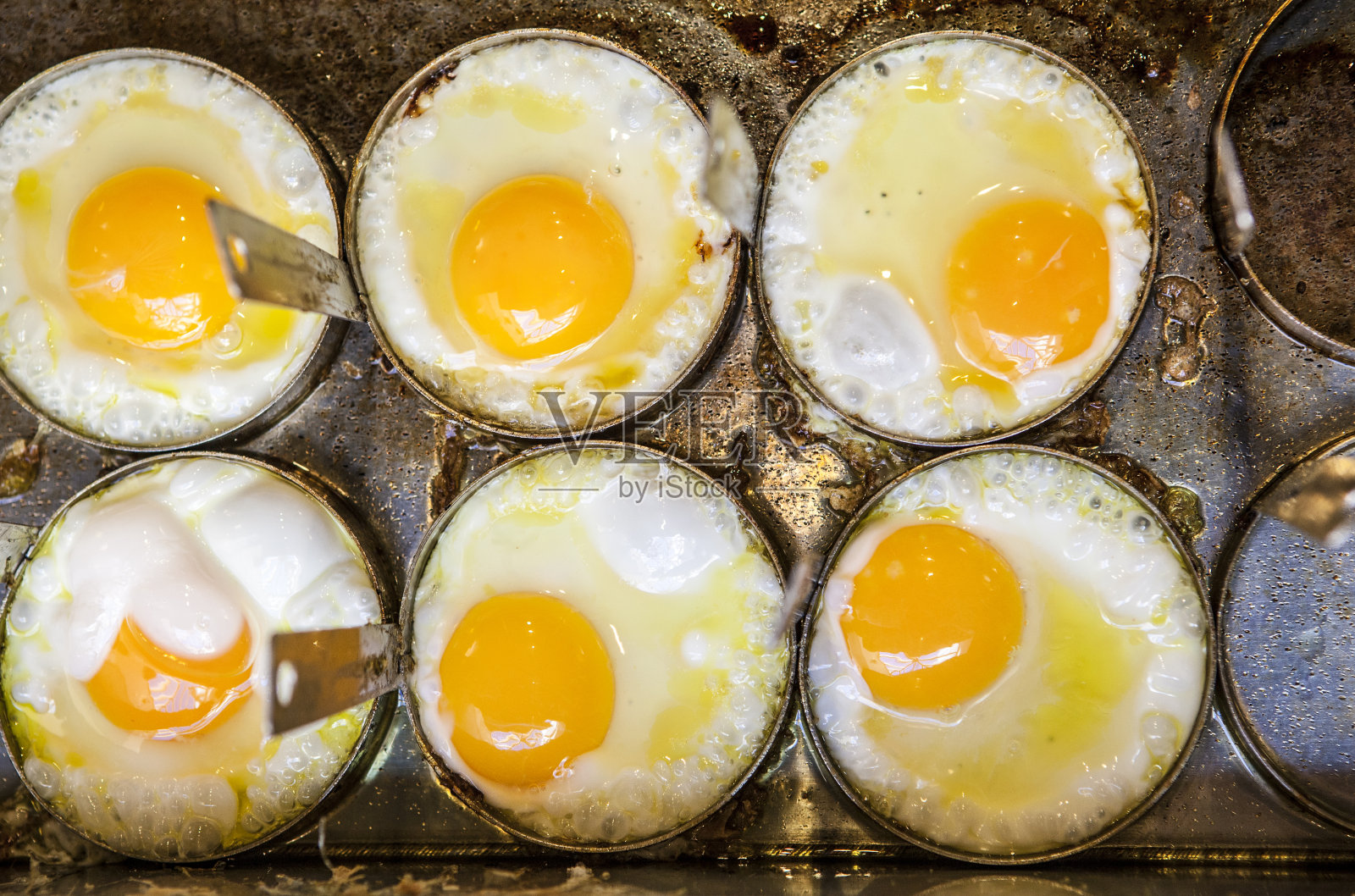 用模具在煎锅上煎六个鸡蛋照片摄影图片