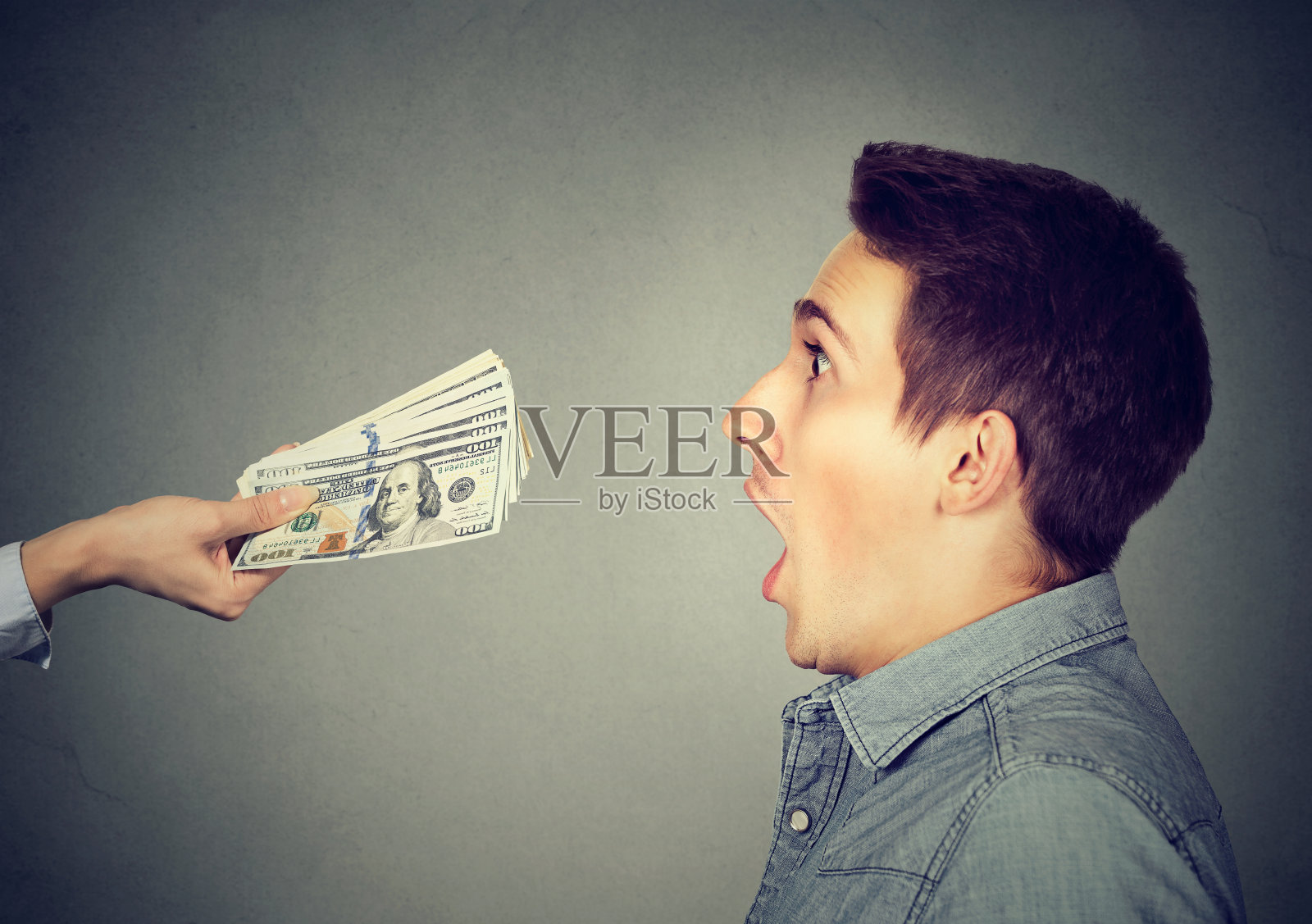 一名男子吃惊地看着眼前的现金钞票照片摄影图片
