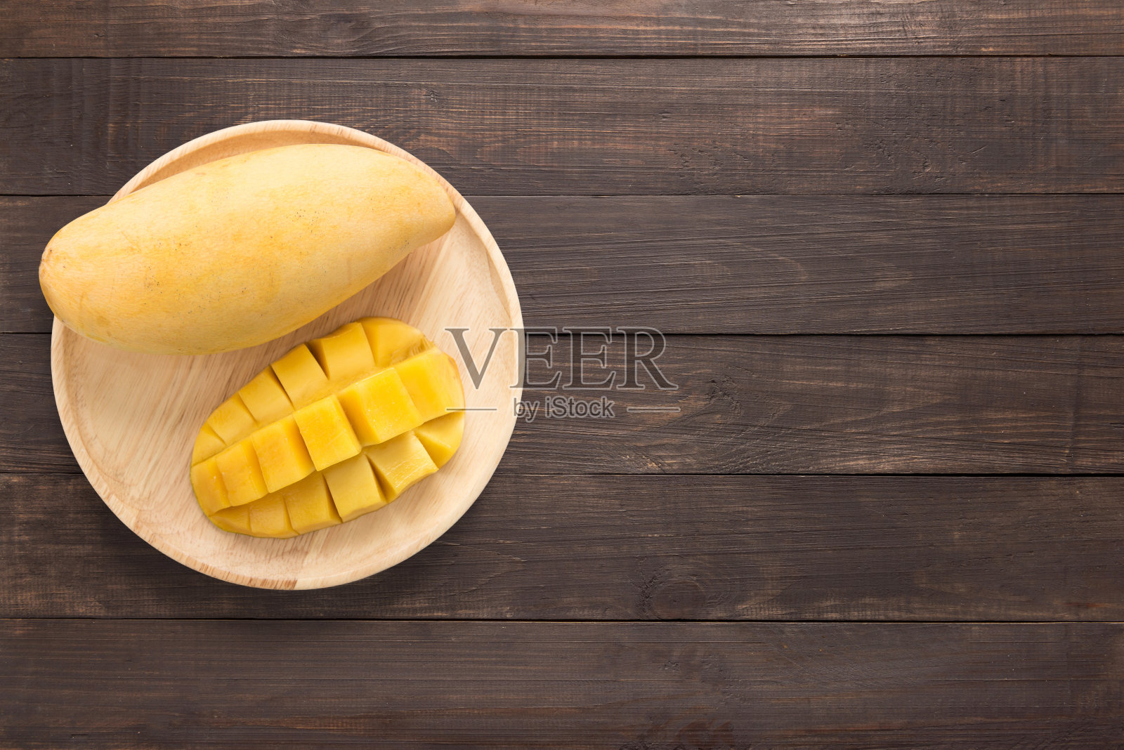 木制背景上的黄色芒果。文本复制空间照片摄影图片