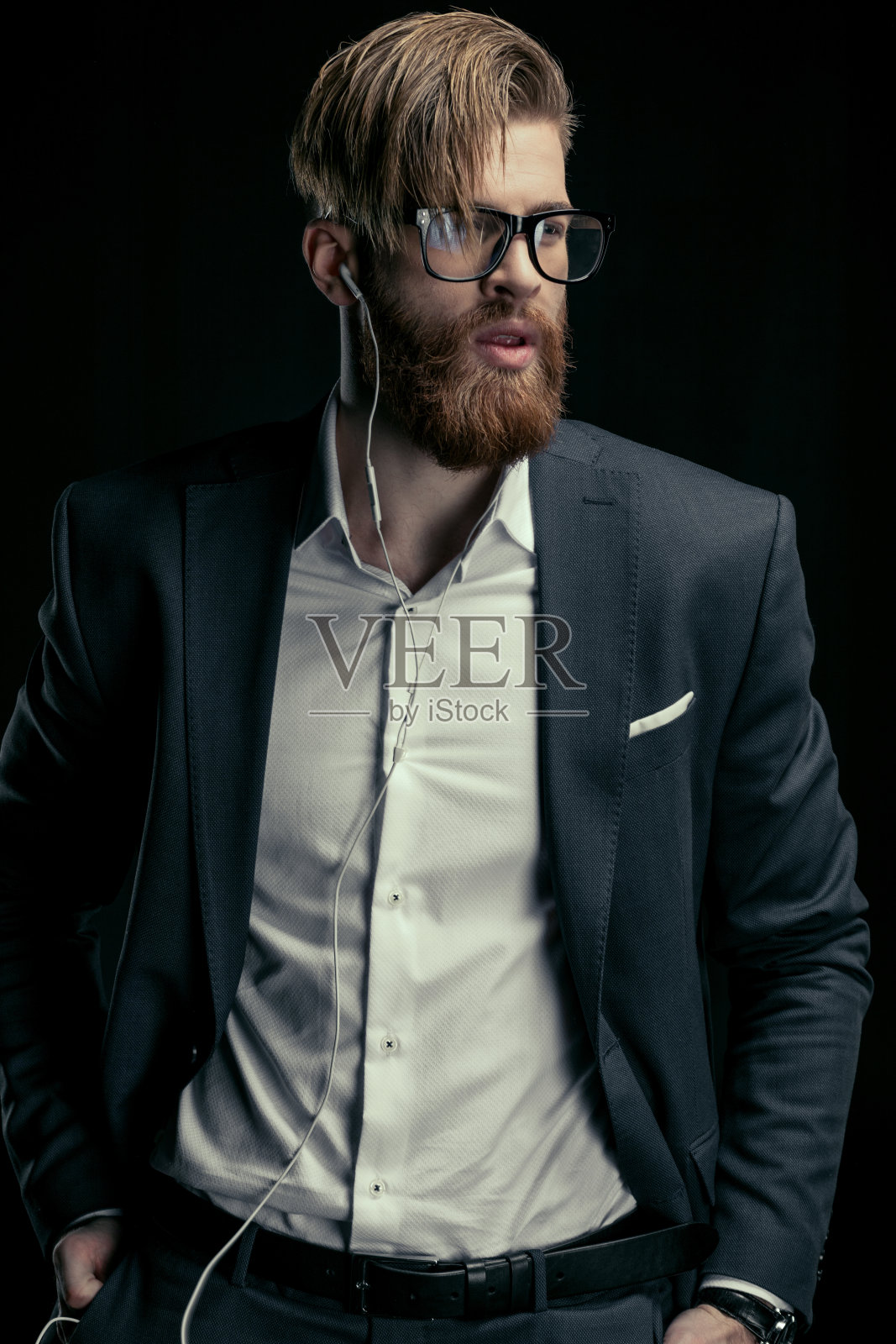 这是一位戴着耳机听音乐的时尚男士的肖像照片摄影图片