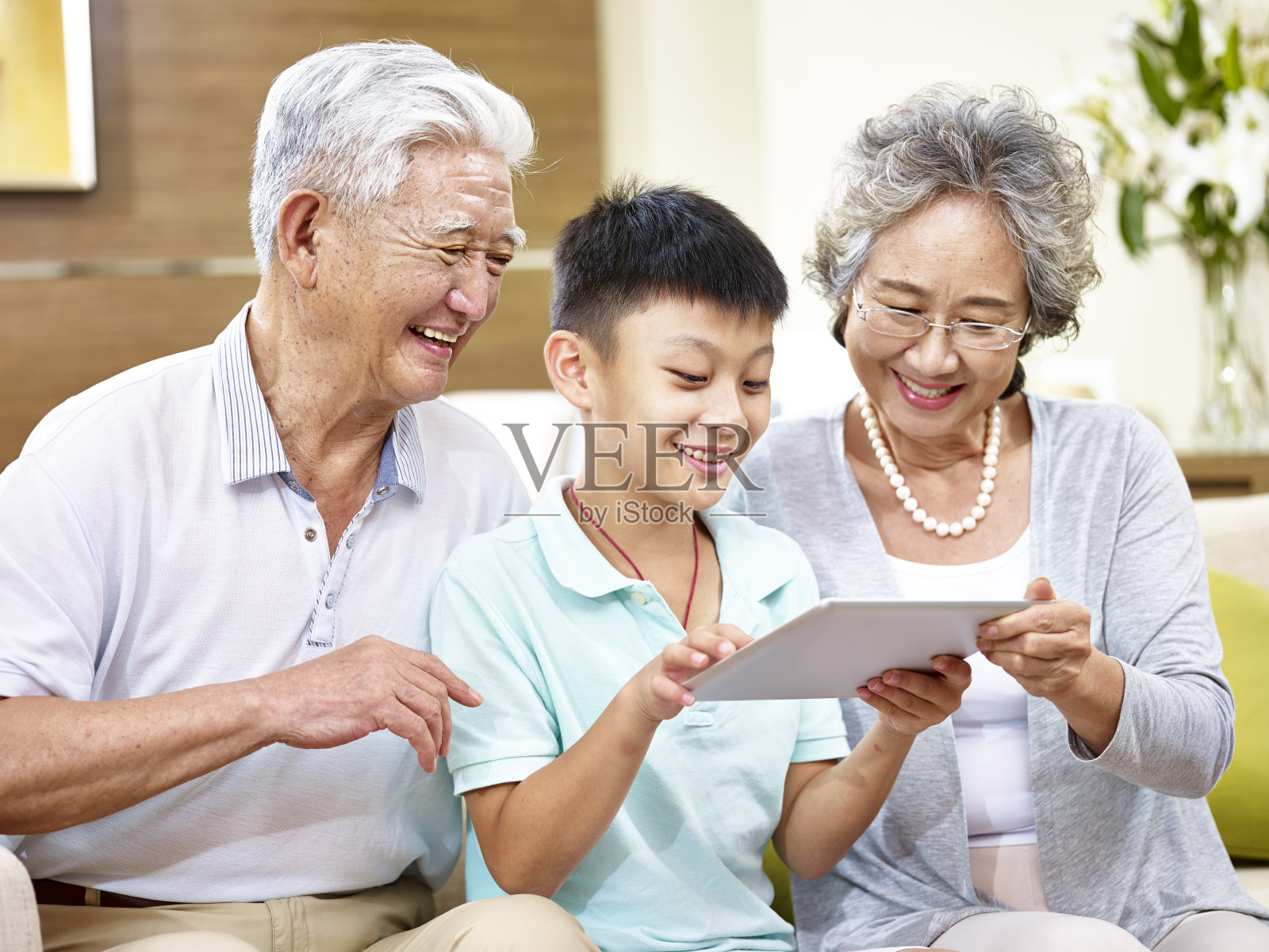 亚洲的祖父母和孙子一起使用数字平板电脑照片摄影图片