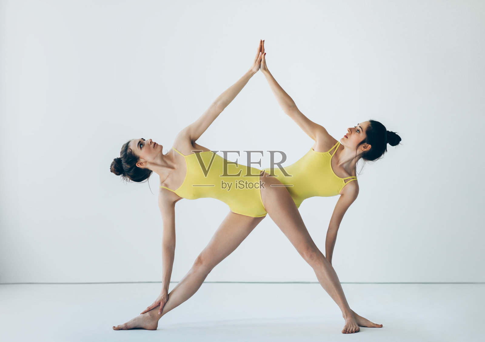 两个美丽的女人做瑜伽体式伸展三角姿势照片摄影图片