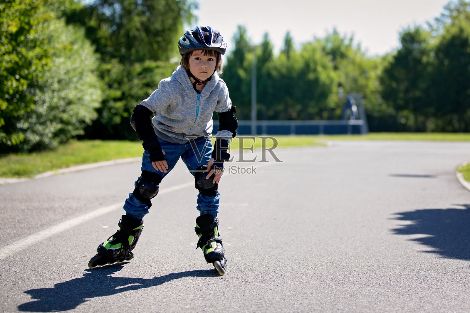 可爱的小男孩，在公园里滑旱冰鞋，春天照片摄影图片