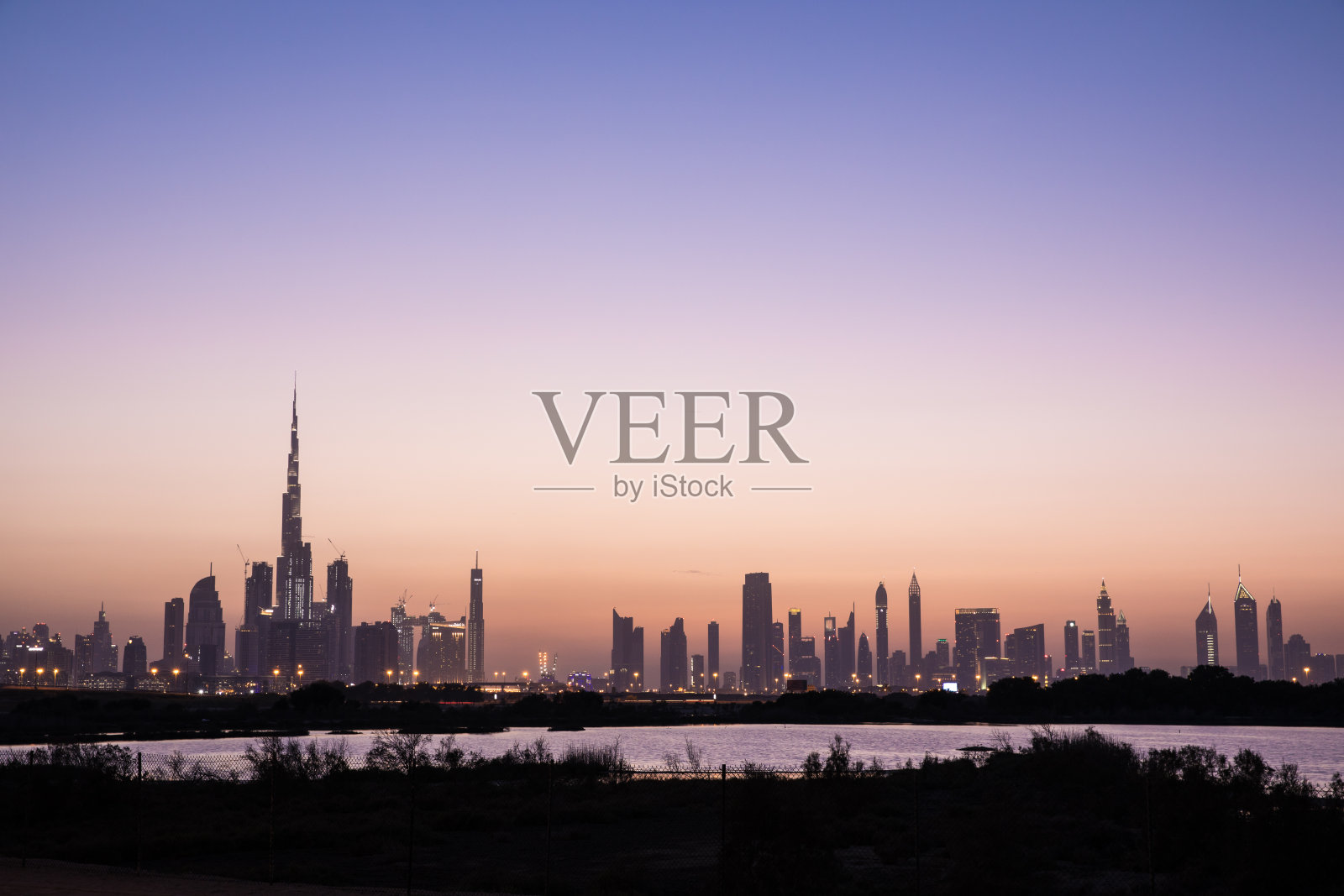 日落时迪拜市中心的天际线。照片摄影图片