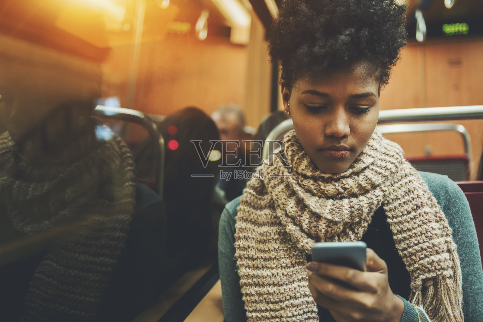 在火车车厢里拿着智能手机的黑女孩照片摄影图片
