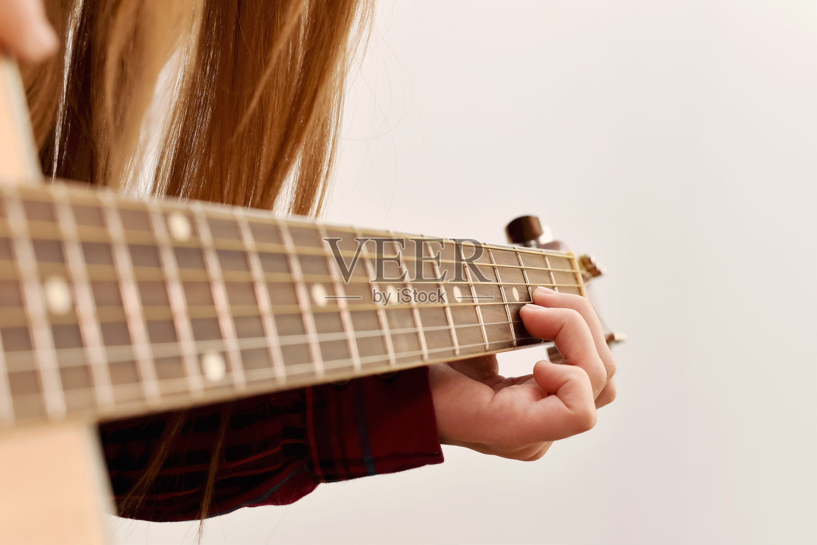 女人的手在弹原声吉他，靠近点照片摄影图片