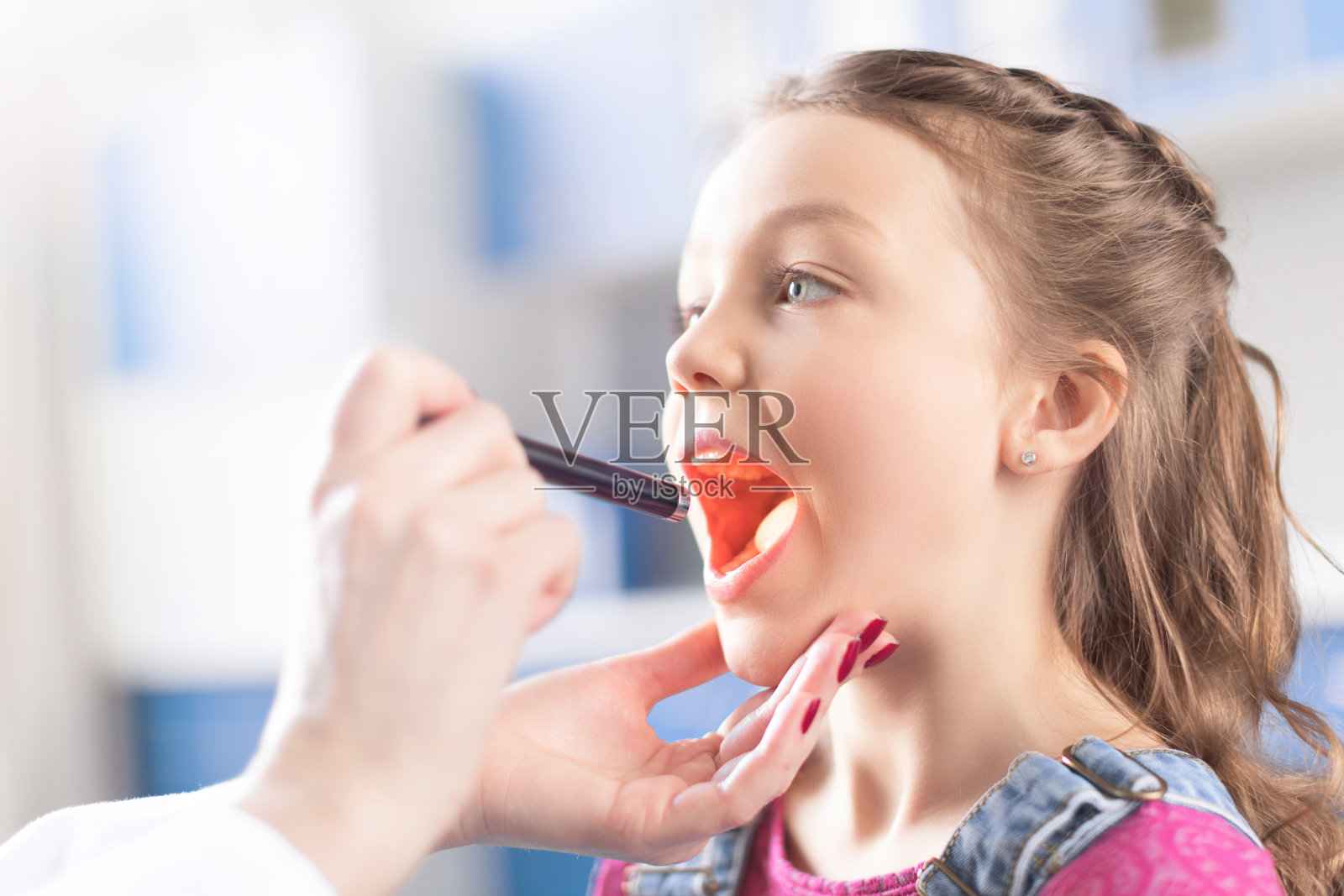 女医生检查小女孩喉咙的镜头照片摄影图片