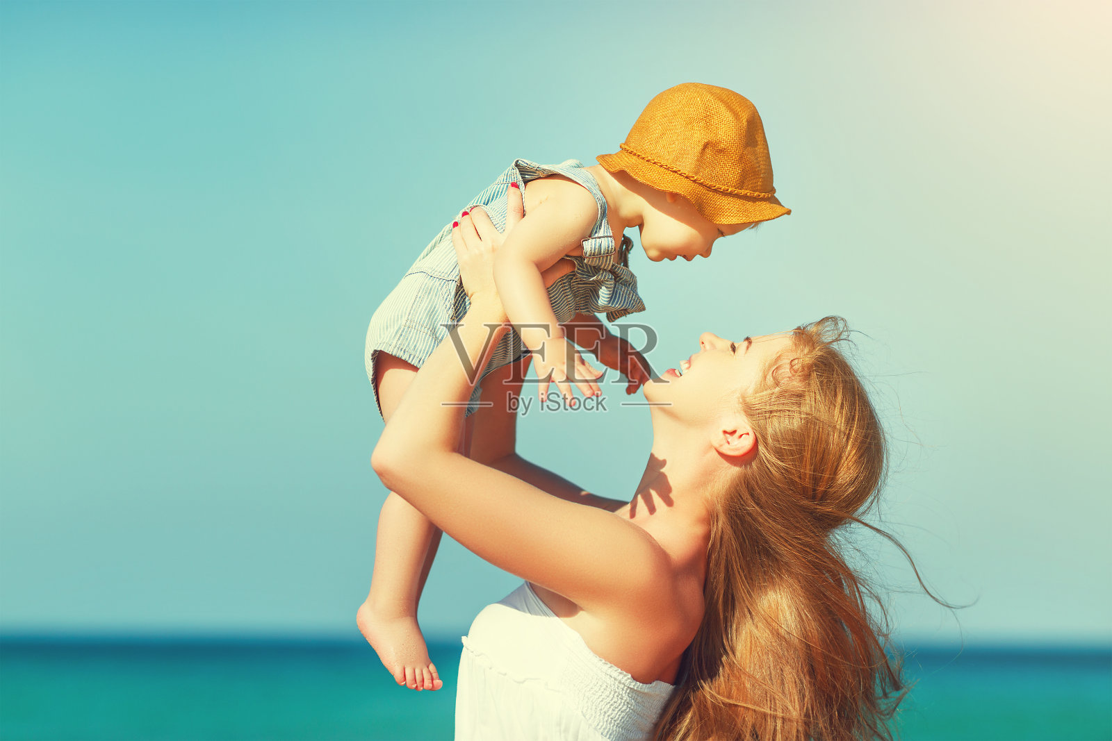 快乐的家庭妈妈和宝宝在夏天的海滩上走在海边照片摄影图片