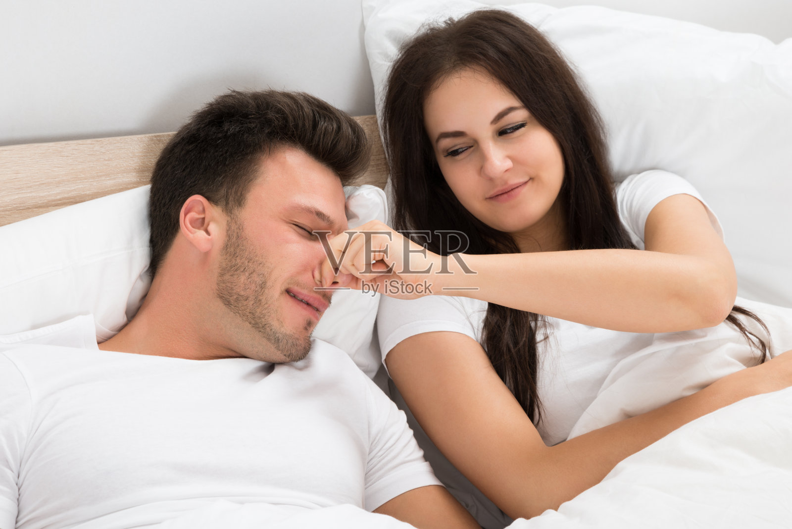 女人在睡觉时抱着丈夫的鼻子照片摄影图片