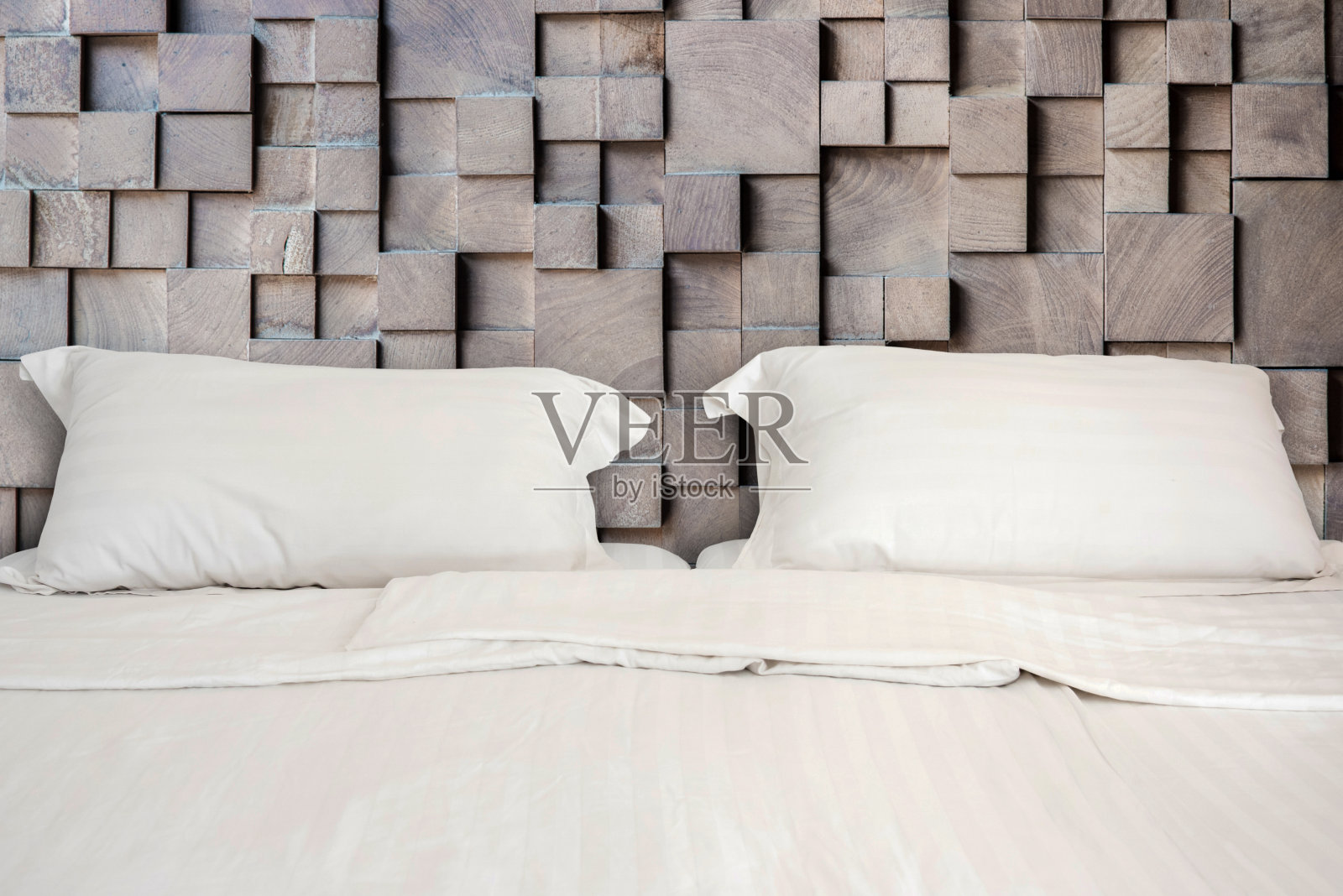 白色的床和两个枕头在木质墙壁房间的背景照片摄影图片