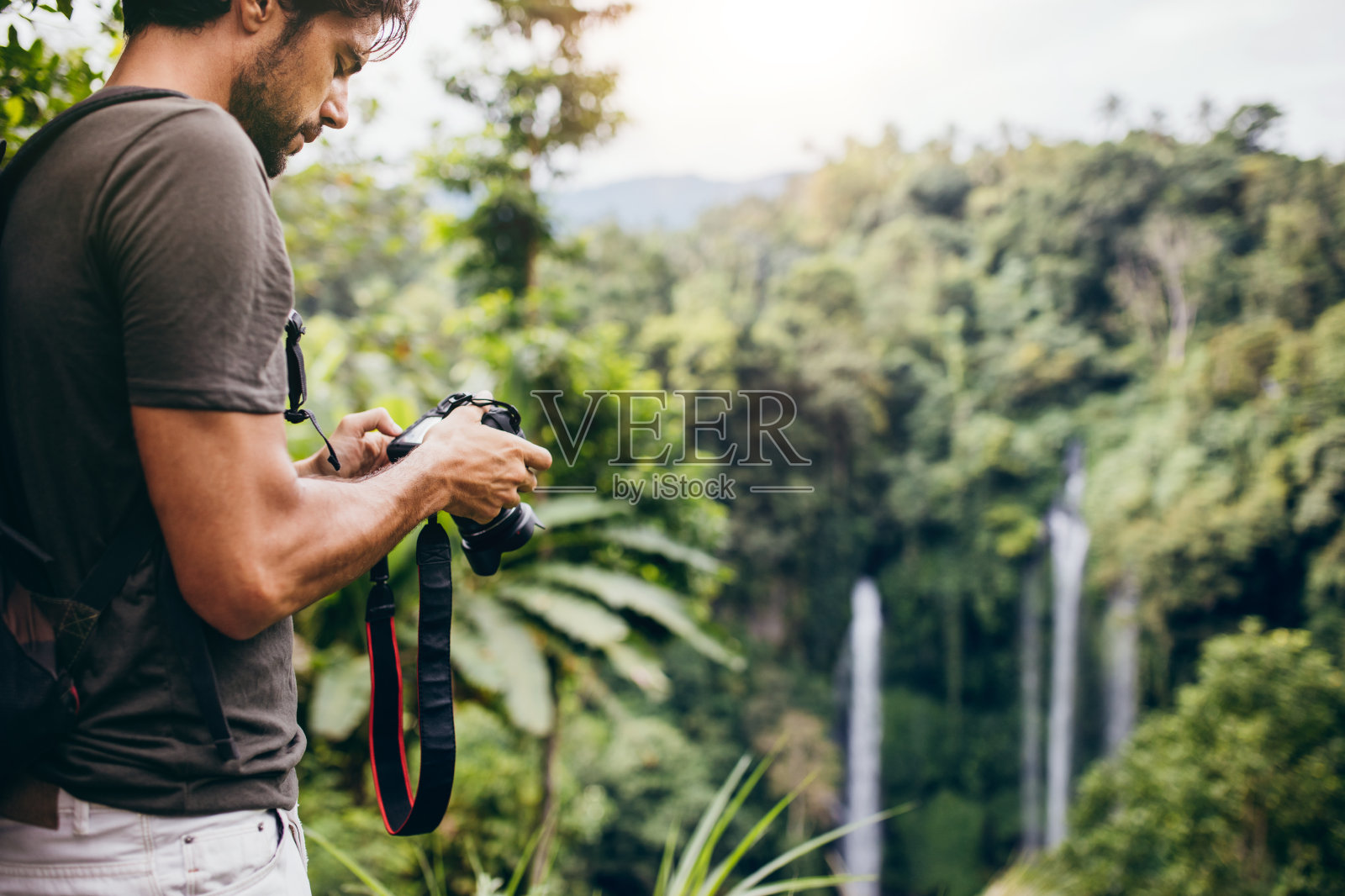 男徒步旅行者在森林里拍摄瀑布照片摄影图片