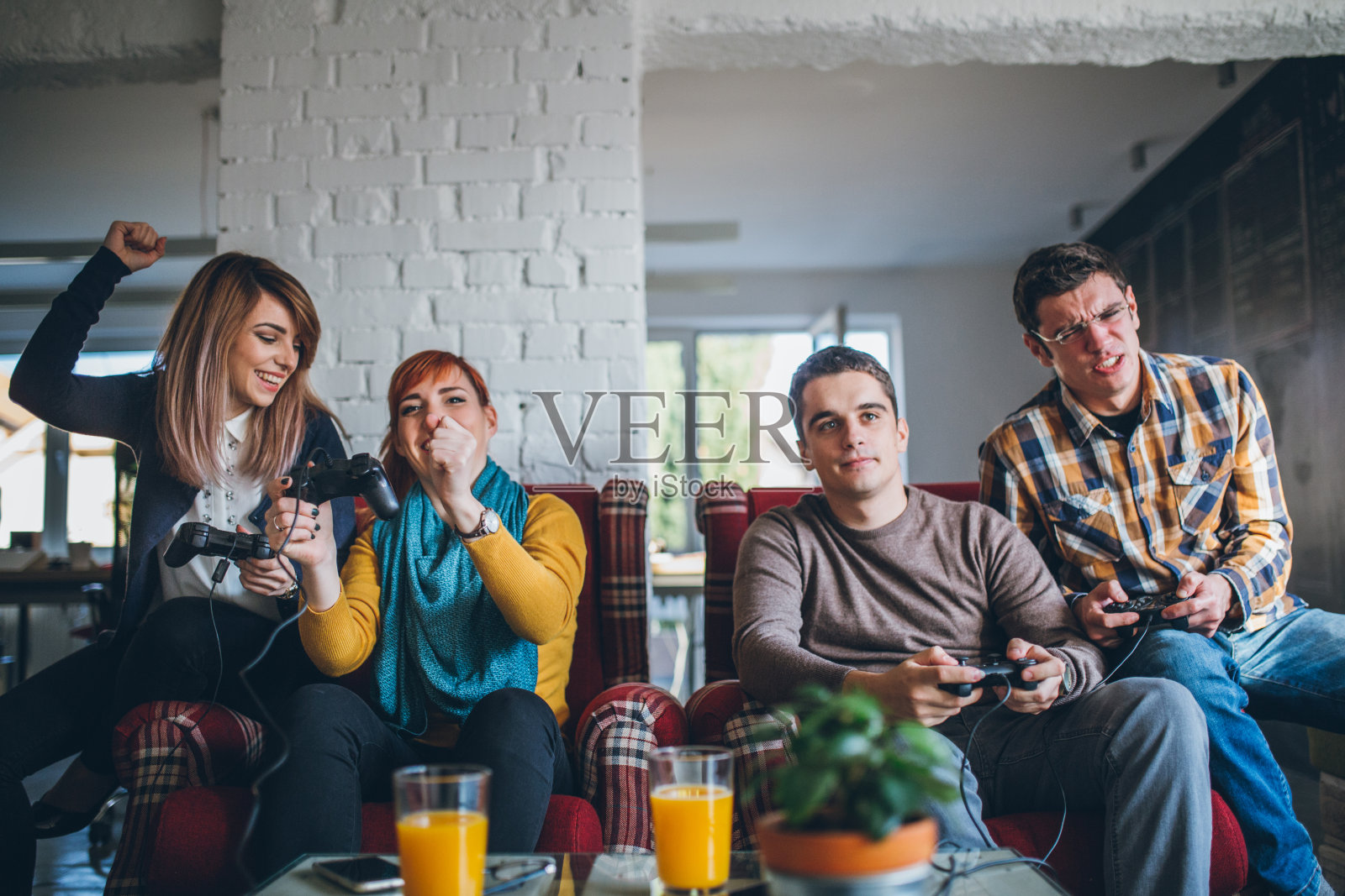 一群朋友在家里玩电子游戏。照片摄影图片