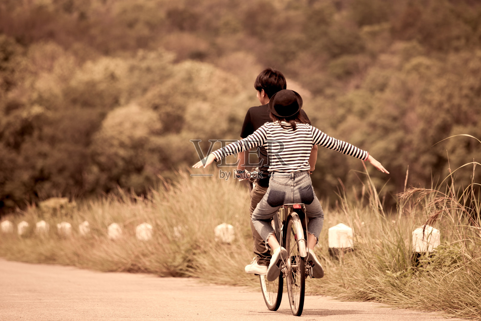 一对年轻的潮人一起骑自行车的后视镜照片摄影图片