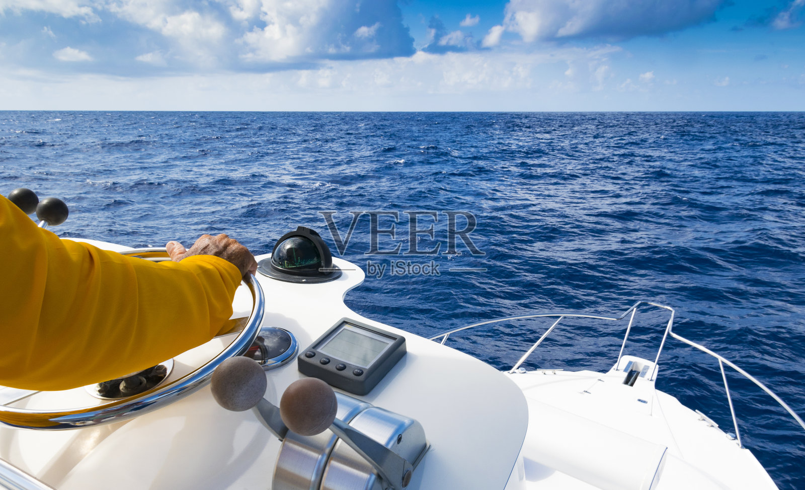 在蓝色的海洋中，舵轮上的船长的手照片摄影图片