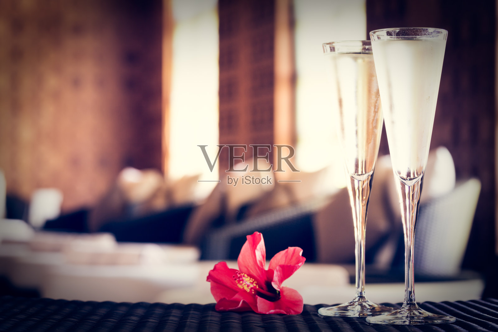 两杯带红花的香槟在水疗休息室。温泉的时间概念。Spa休息区。照片摄影图片