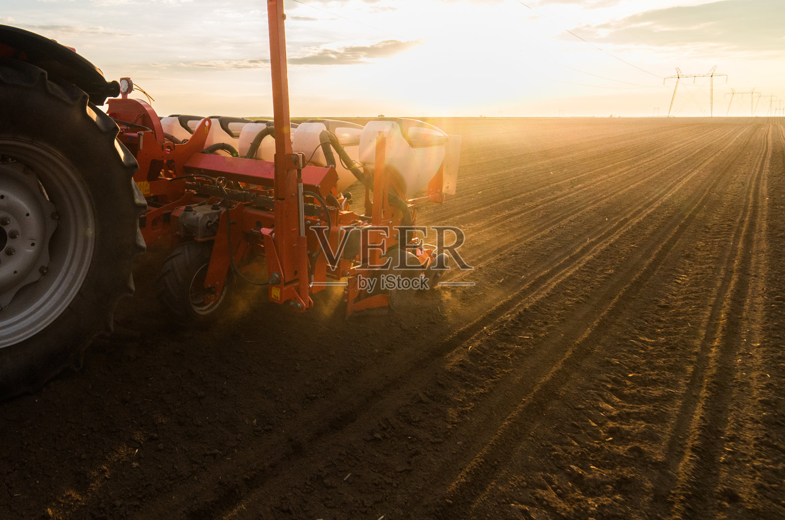 农民在春天用拖拉机播种，在农田里播种庄稼照片摄影图片