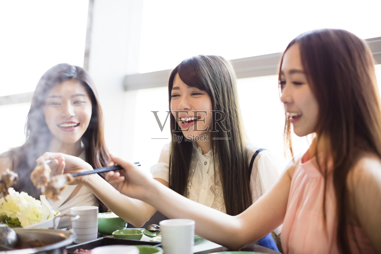 快乐的年轻女性团体吃火锅照片摄影图片