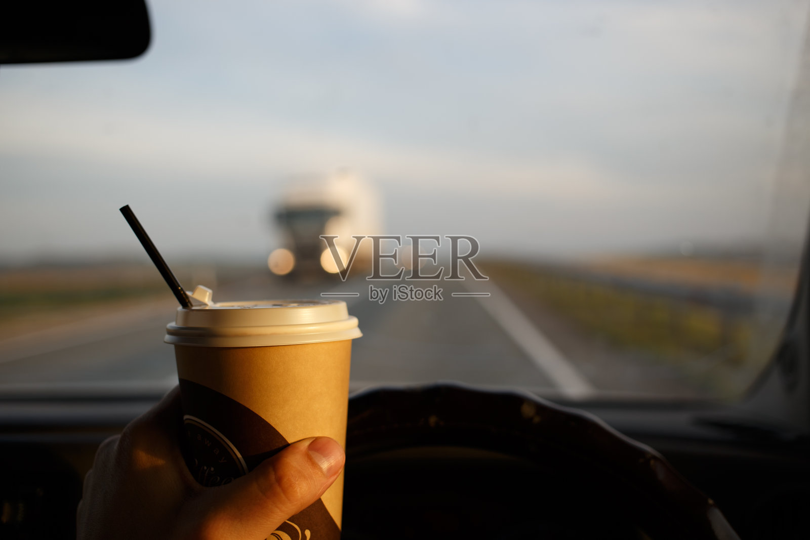 在车里喝咖啡。在方向盘上吃东西时发生紧急情况照片摄影图片