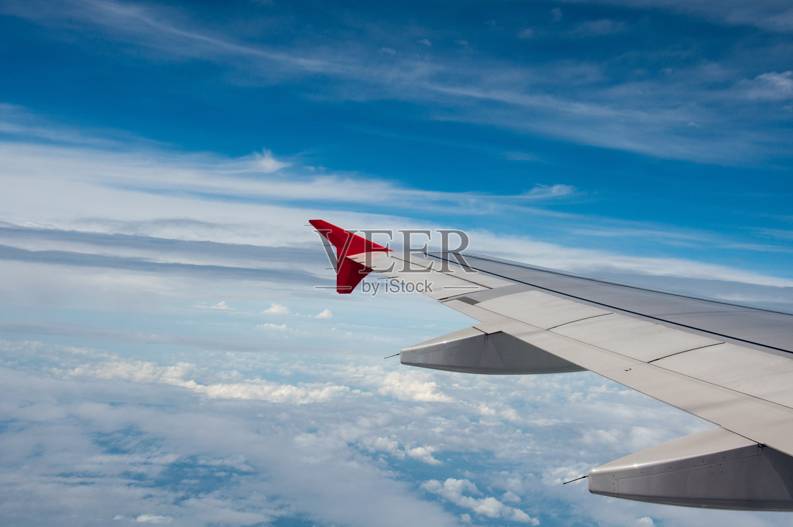 在飞机上看窗外的时候。你可以看到天空和飞机机翼的云彩。-概念云，飞机，天空。照片摄影图片