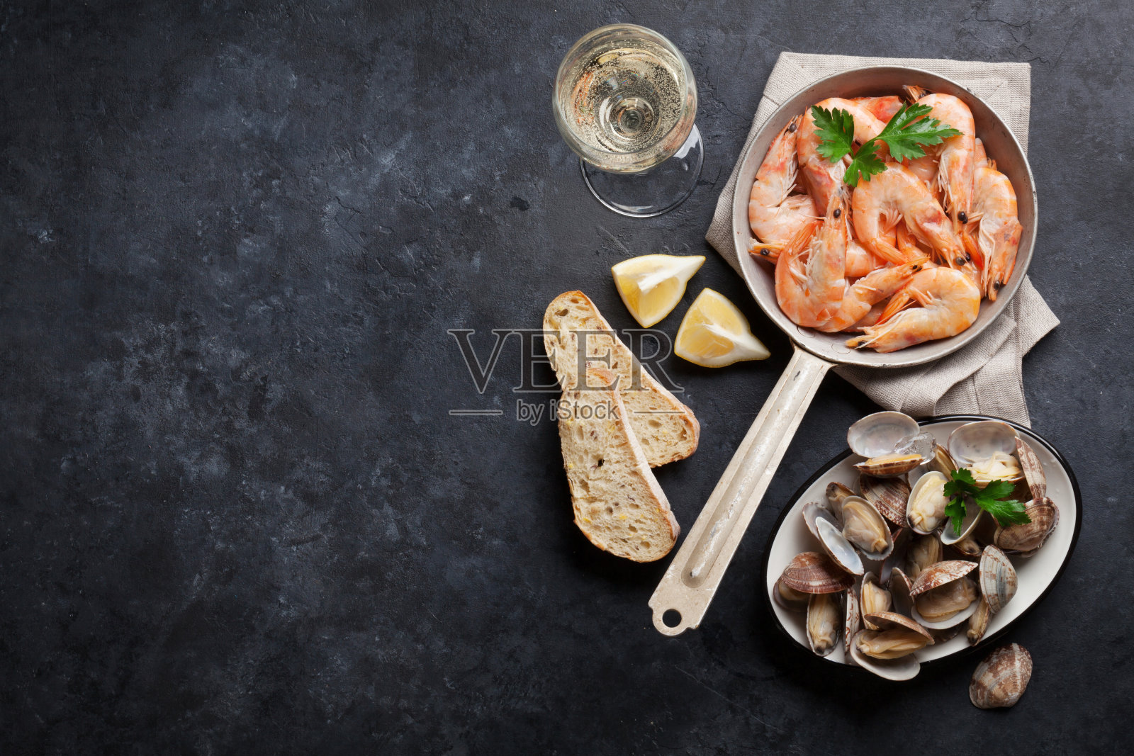 新鲜的海鲜在石头桌上。扇贝和虾照片摄影图片
