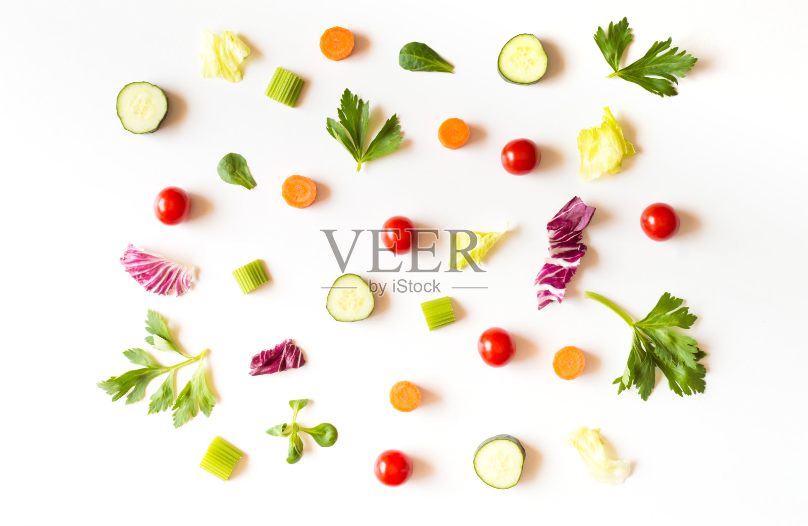 以沙拉、生菜叶、黄瓜、红番茄、胡萝卜、芹菜为食，白色背景照片摄影图片