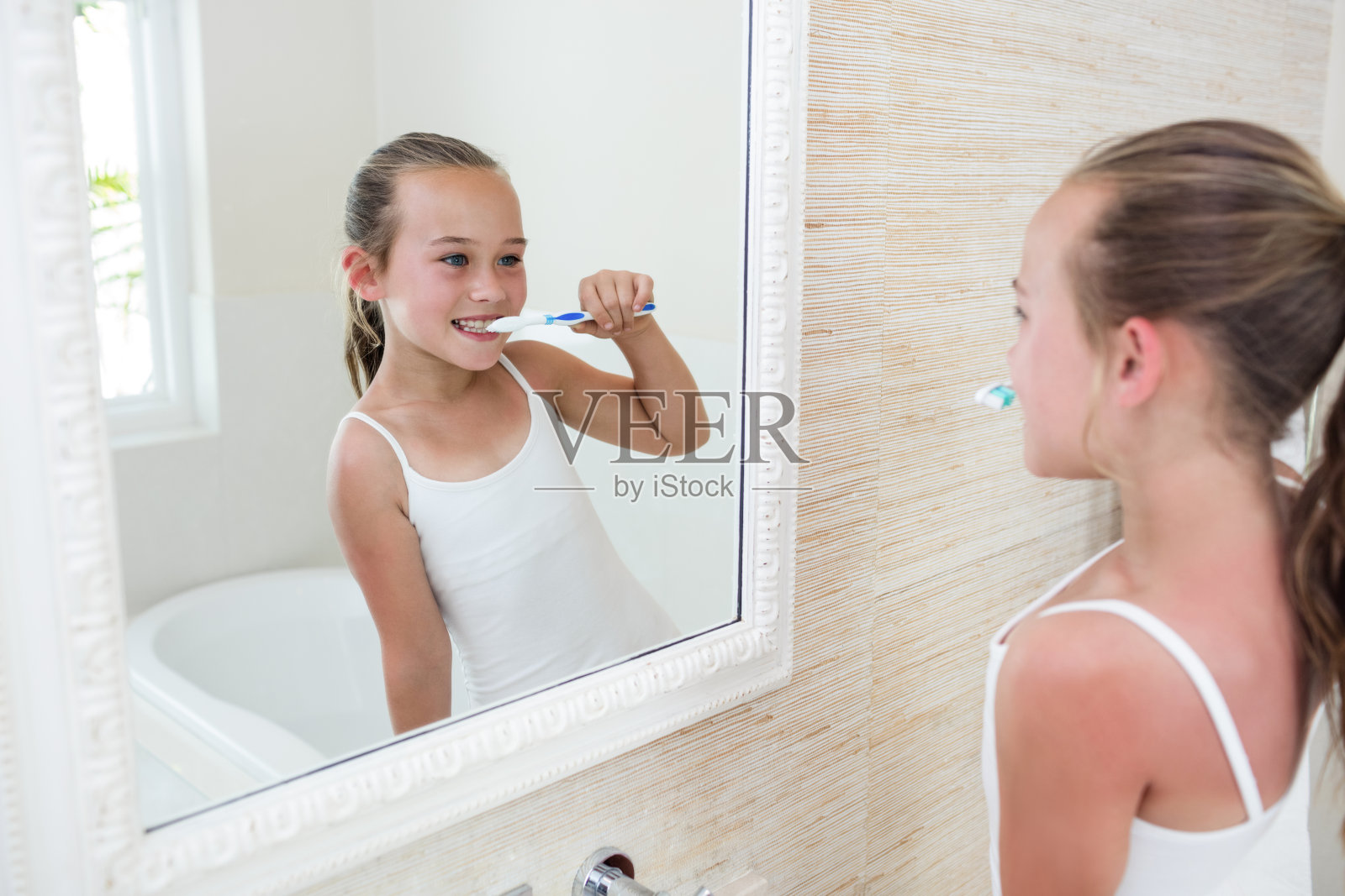 快乐女孩在浴室里刷牙照片摄影图片