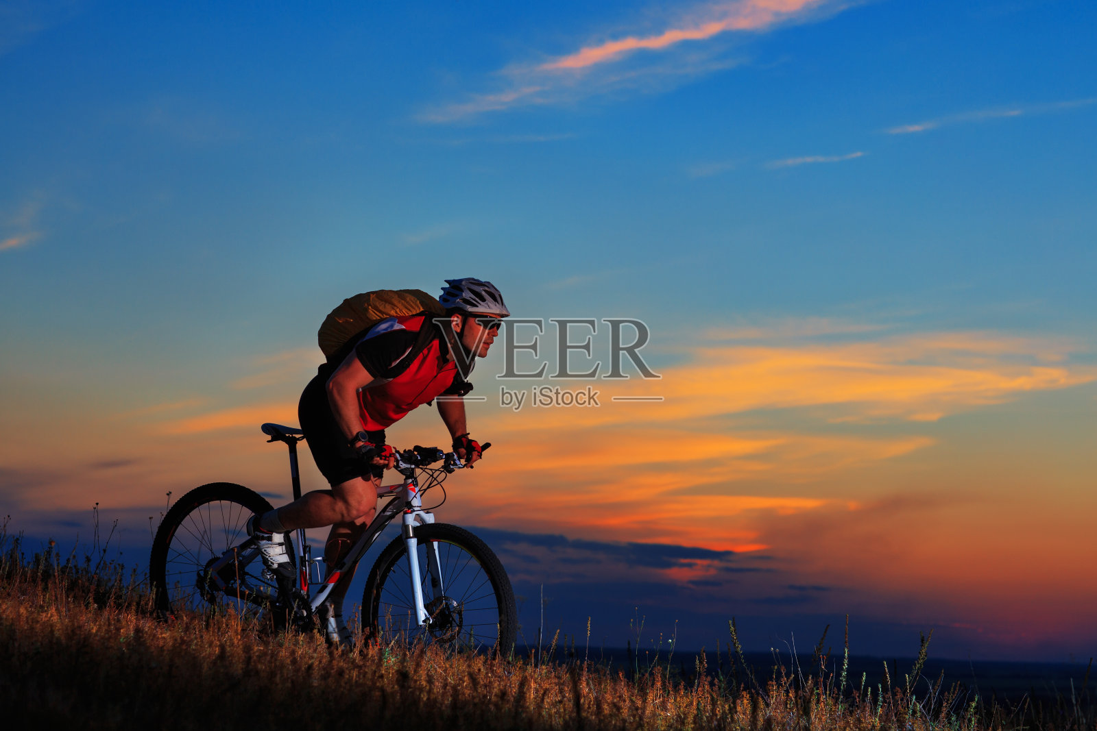 在日落的背景上，摩托车和自行车的剪影。照片摄影图片