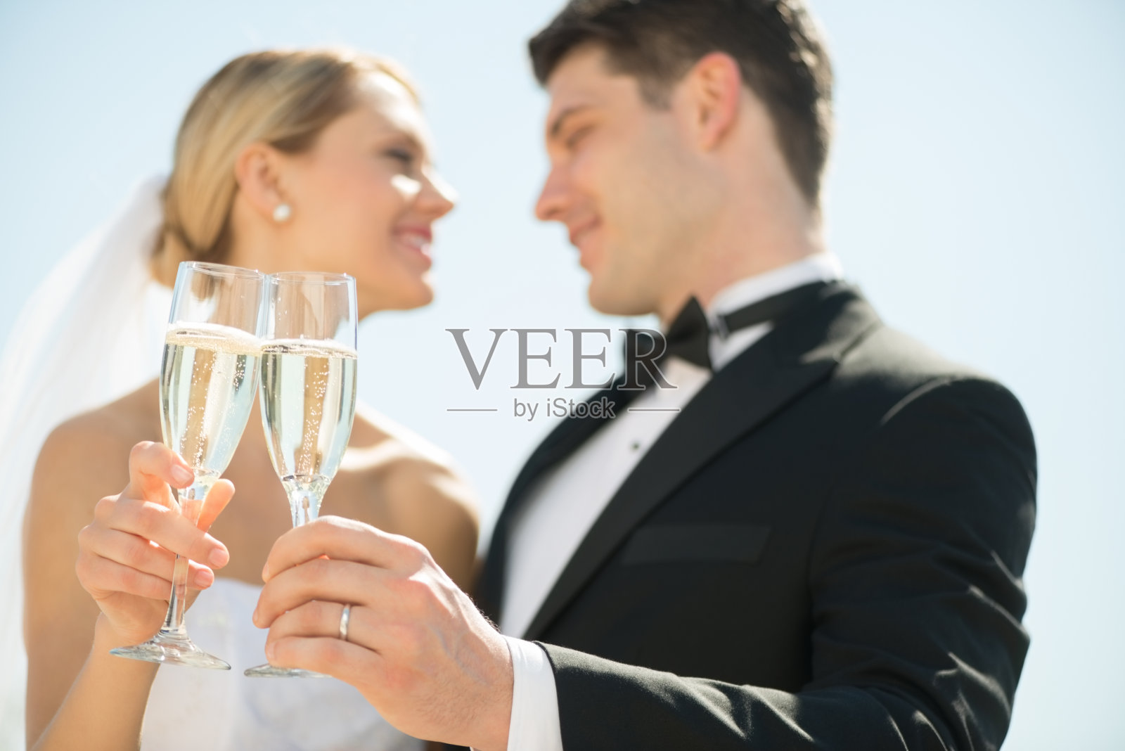 新娘和新郎对着天空用香槟杯敬酒照片摄影图片
