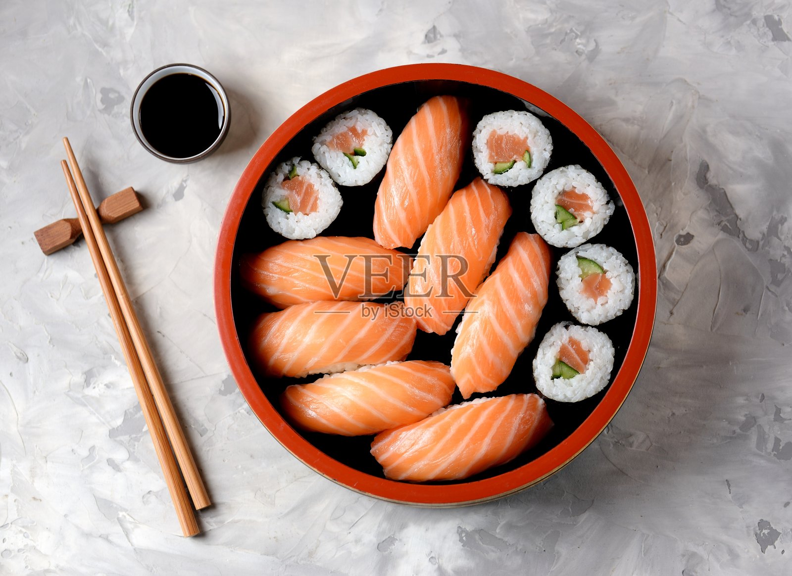 自制寿司，新鲜的三文鱼和黄瓜在旧的木制背景上。照片摄影图片