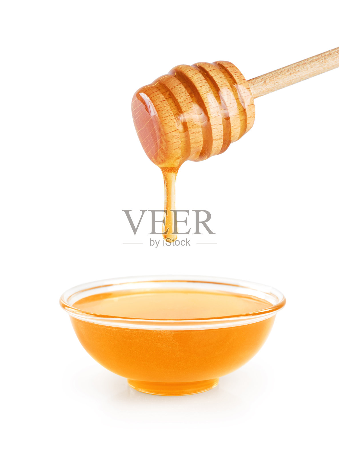 碗蜂蜜和木制蜂蜜勺在白色的背景。照片摄影图片