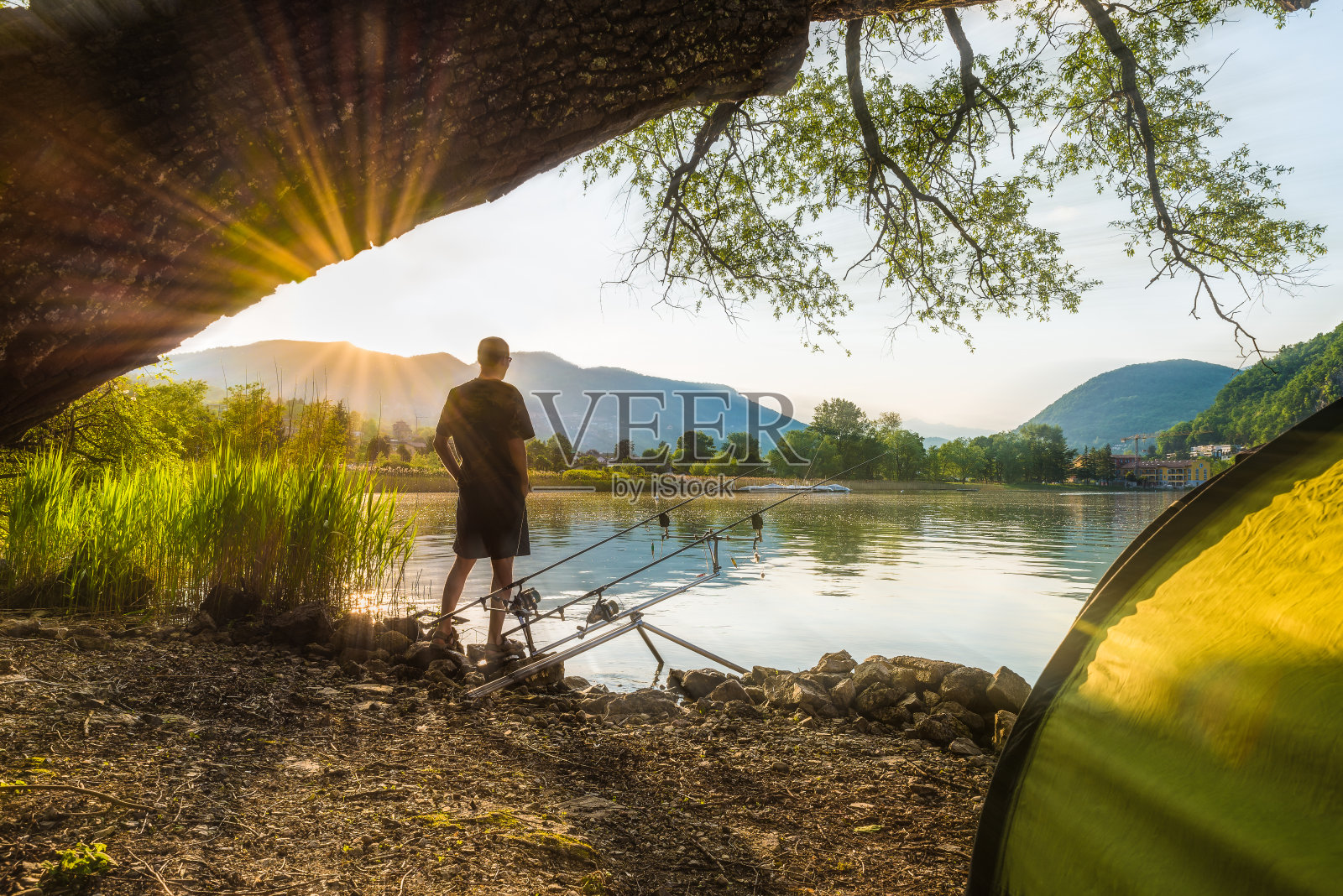 钓鱼历险，钓鲤鱼。夕阳西下，垂钓者正在用钓鲤鱼的技巧钓鱼照片摄影图片
