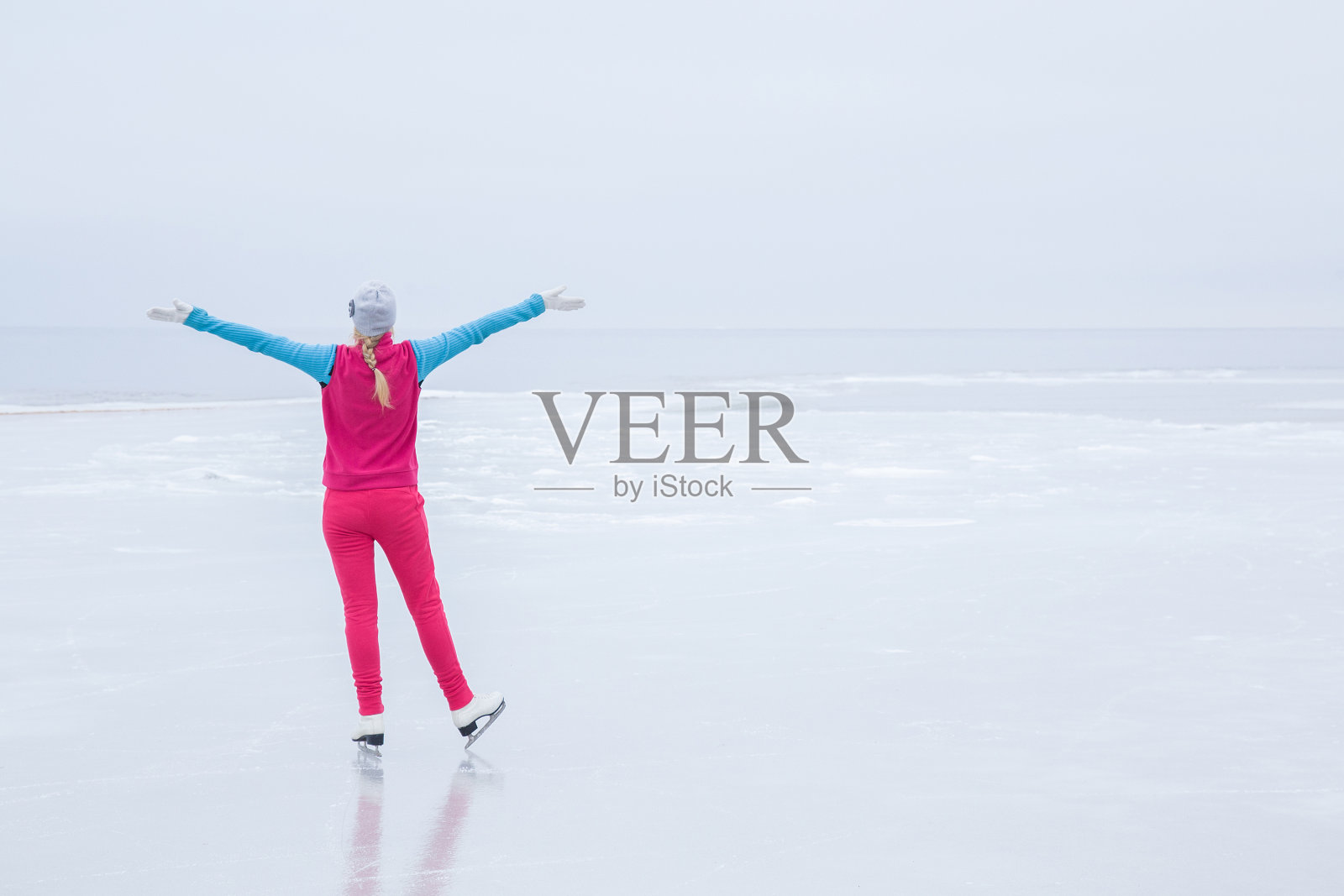 女子滑冰和训练与白色冰鞋。周末户外活动。照片摄影图片