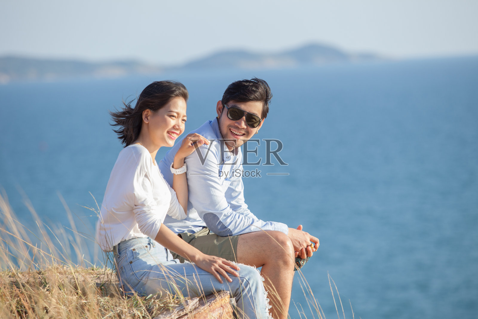 描绘亚洲年轻男女在海边度假放松的幸福情感照片摄影图片