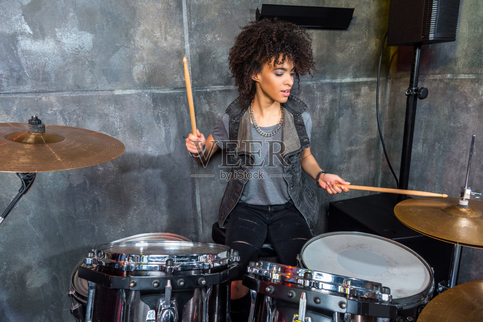 年轻女子在音乐工作室打鼓，鼓手摇滚概念照片摄影图片