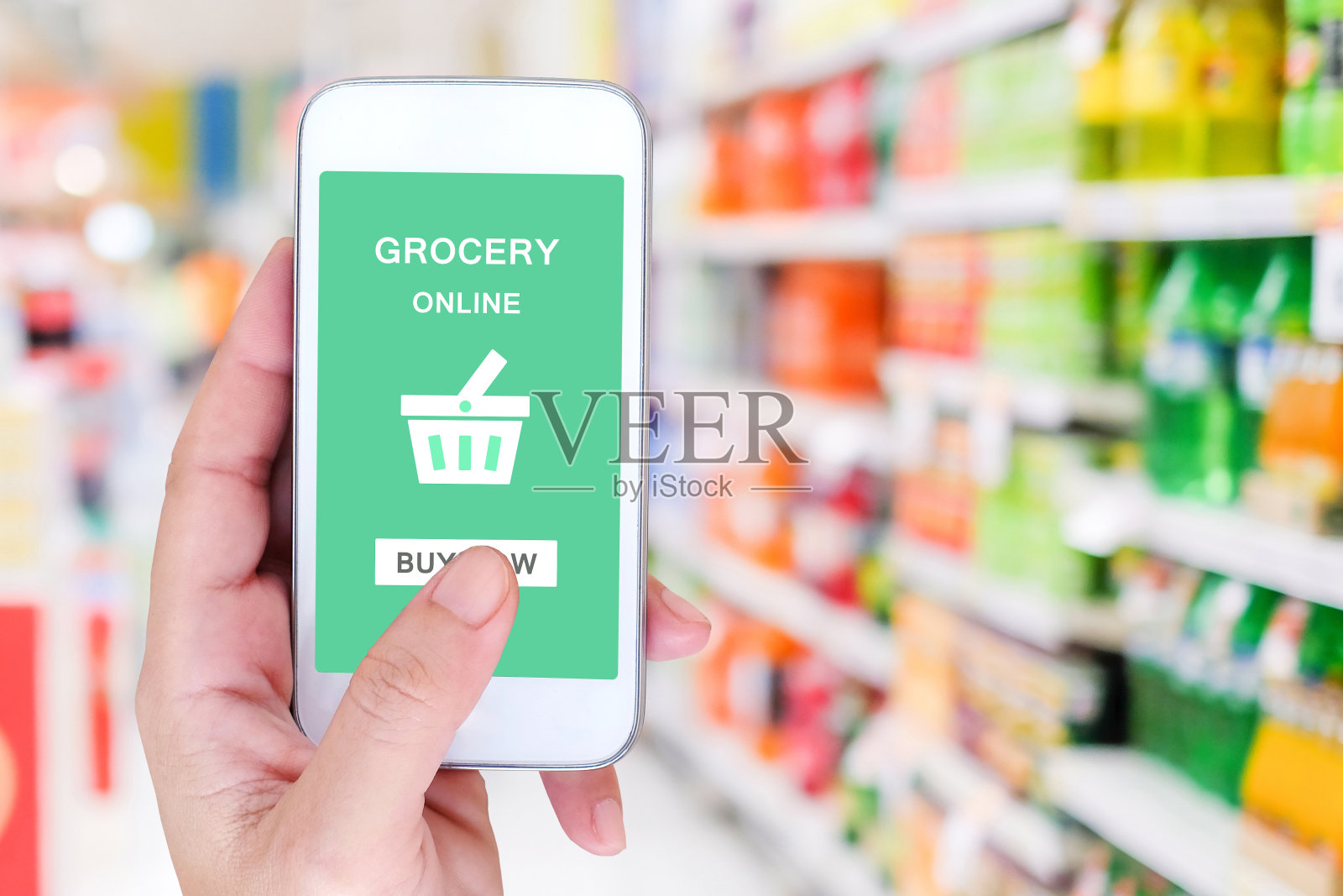 手持智能手机与杂货网上购物屏幕上模糊超市背景，零售业务和技术概念照片摄影图片