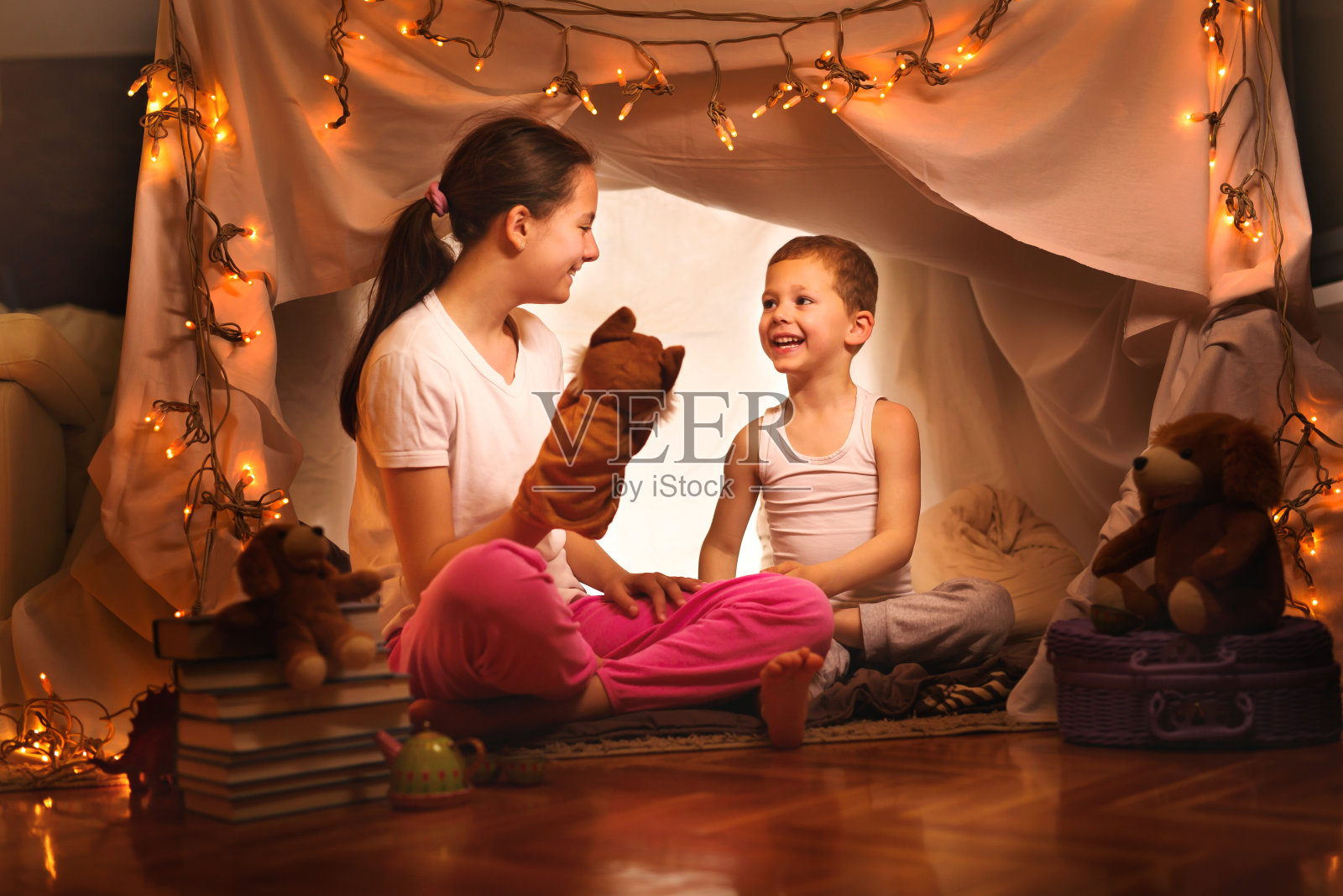 快乐的男孩和女孩在家里的帐篷里玩照片摄影图片