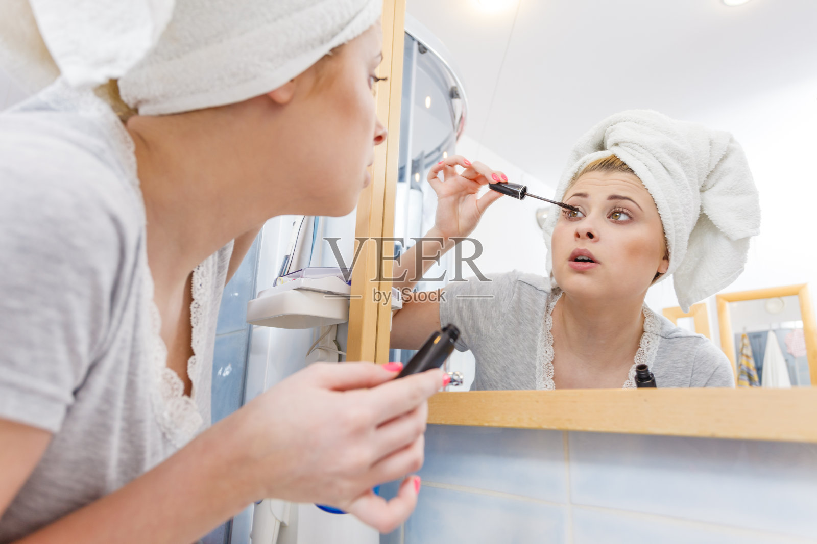 在浴室里涂睫毛膏的女人照片摄影图片