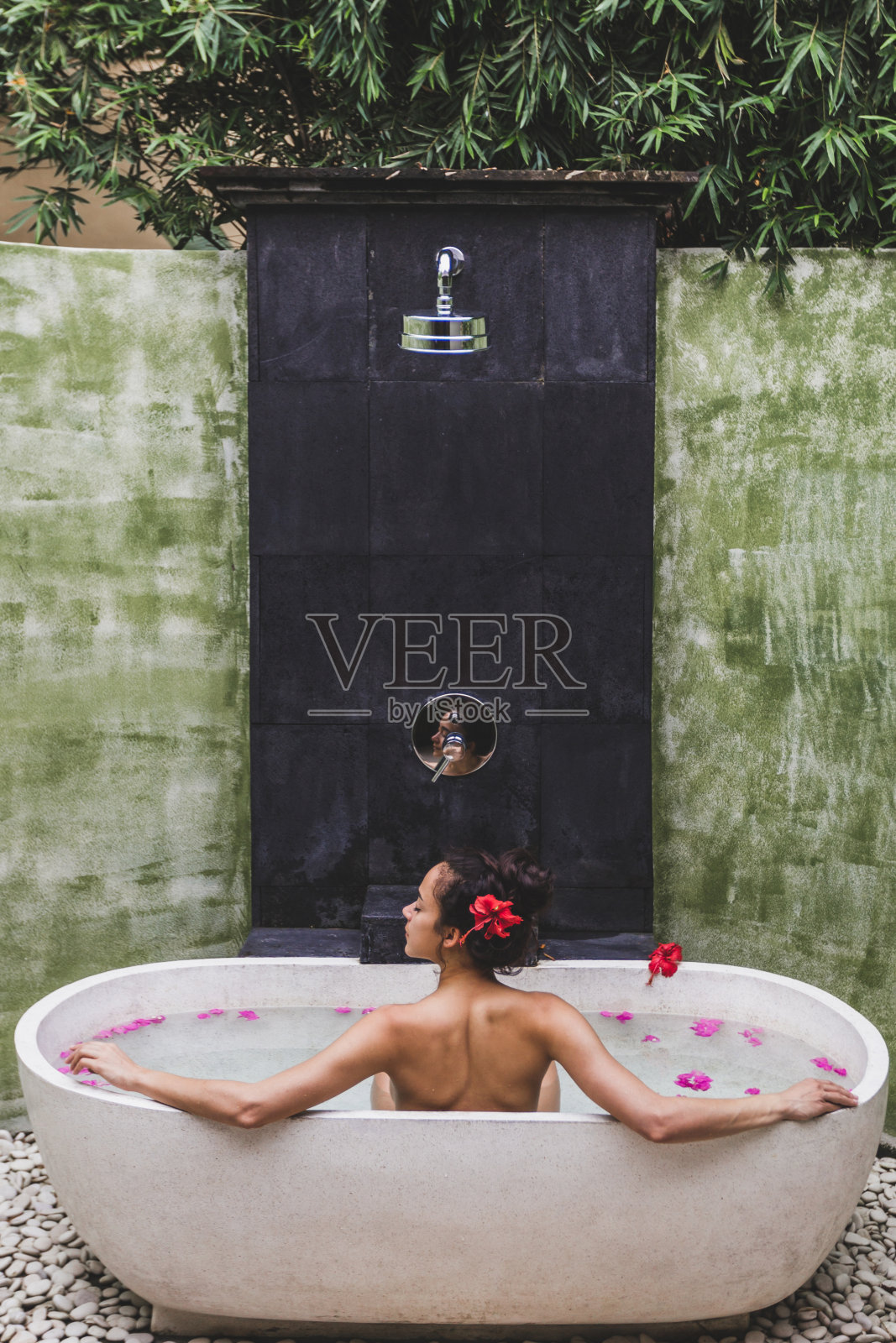女人放松在圆形户外沐浴热带鲜花，有机皮肤护理，豪华水疗酒店，生活方式照片照片摄影图片