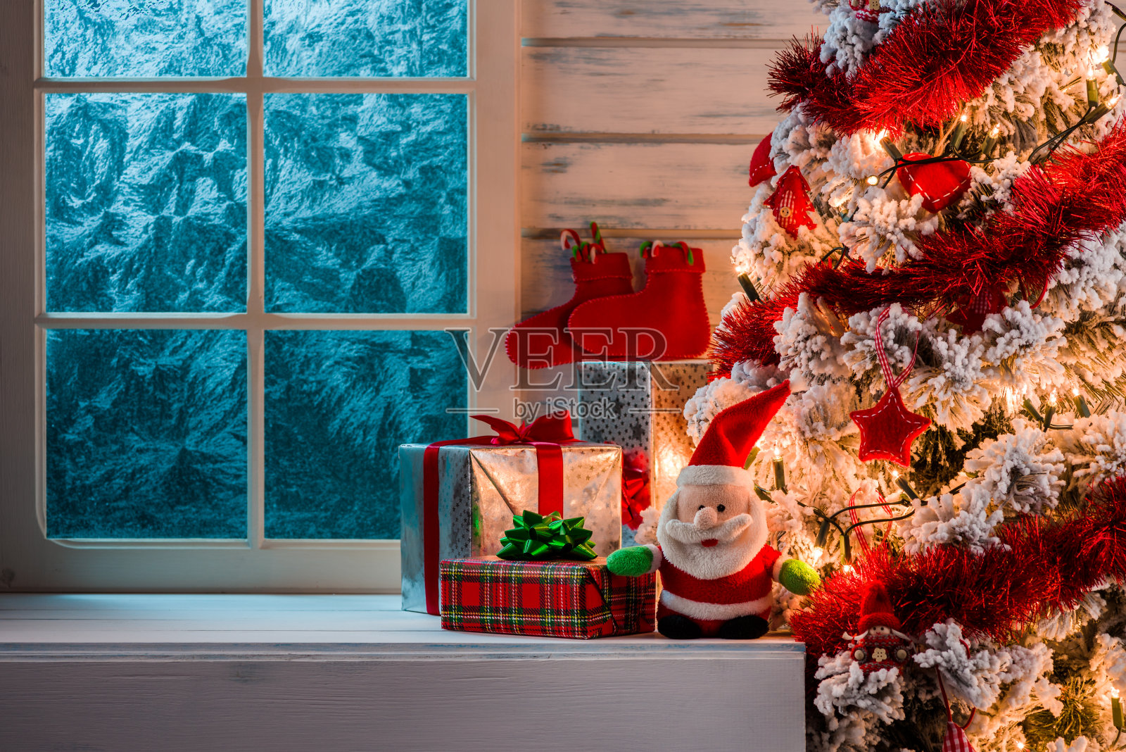 圣诞场景与圣诞树礼物和冻结的窗户在背景照片摄影图片