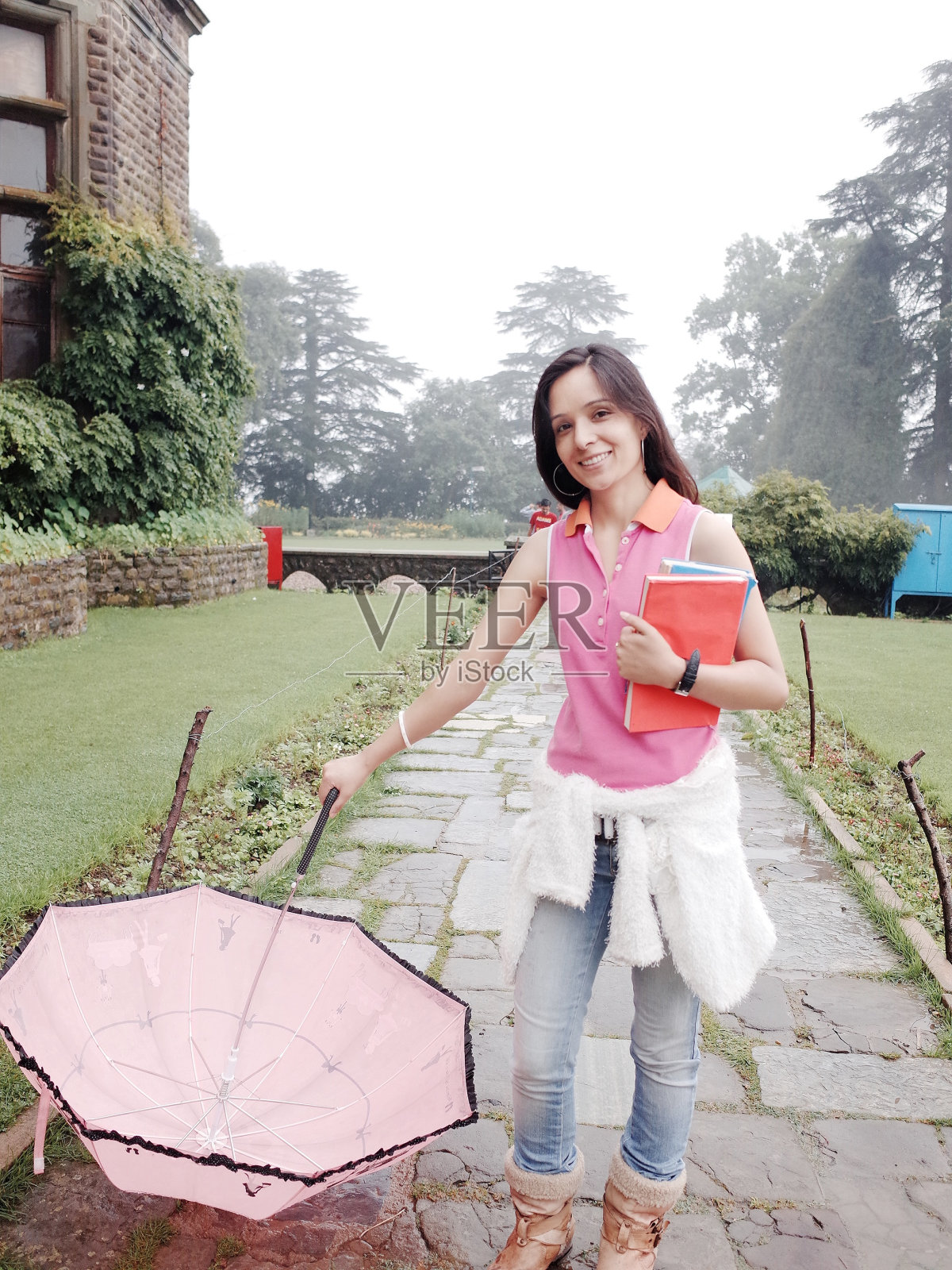 漂亮的印度女学生撑伞的肖像。照片摄影图片