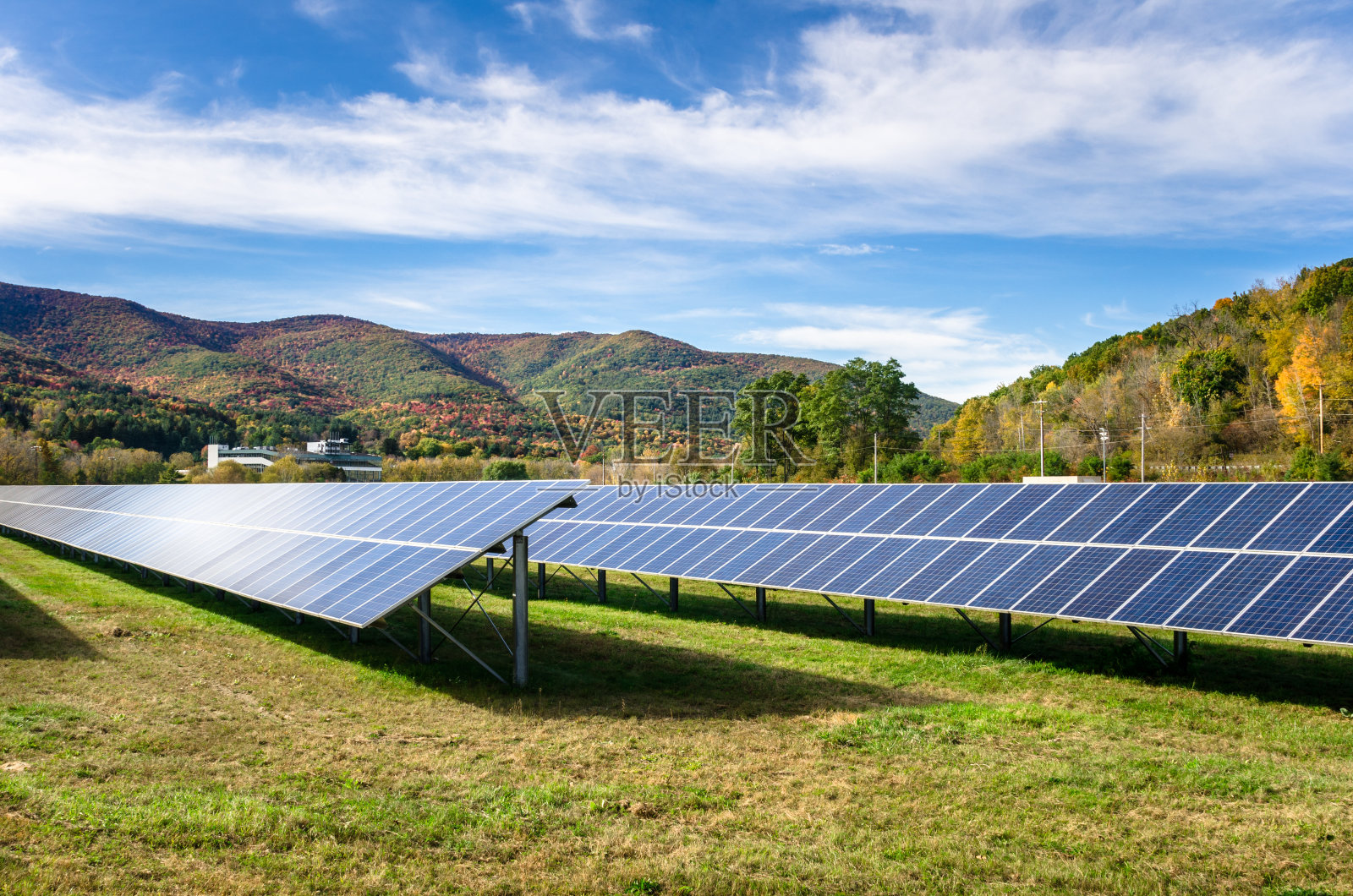 秋天，山脉景观中的一排排太阳能电池板照片摄影图片