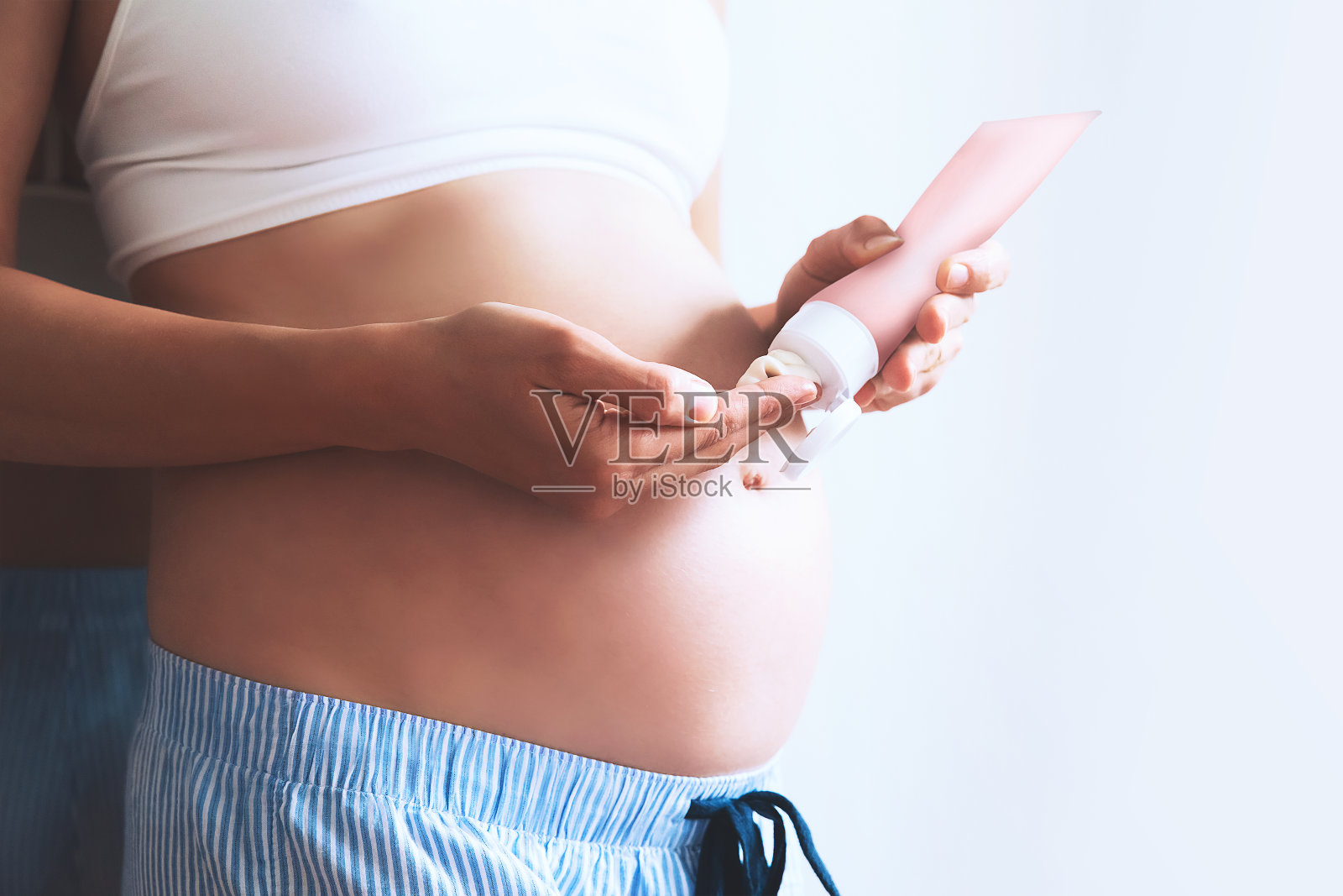 孕妇腹部皮肤护理保湿霜。照片摄影图片