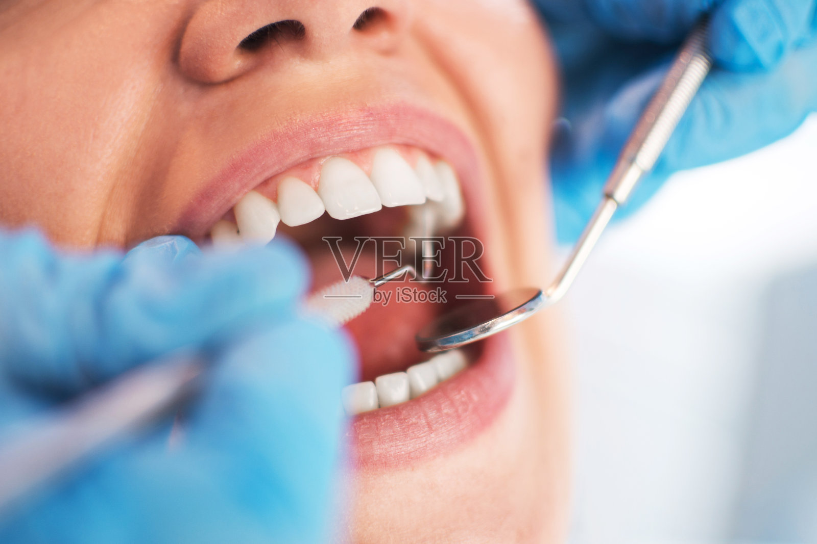 在牙科医生进行口腔检查时，张开女性的嘴。有选择性的照片摄影图片